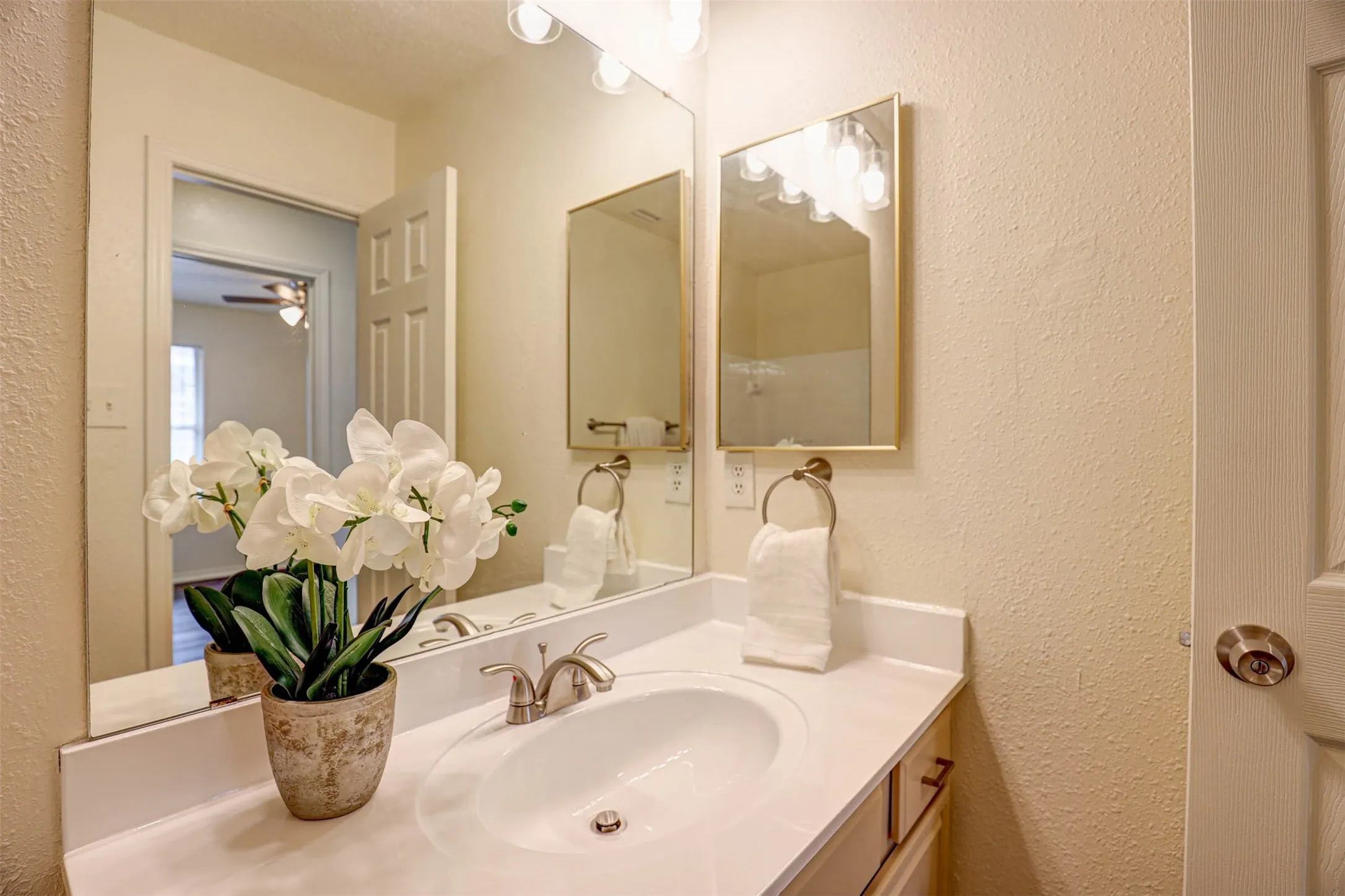 Clean and sparkling hall bath with refinished cabinets and countertop and brushed nickel faucet
