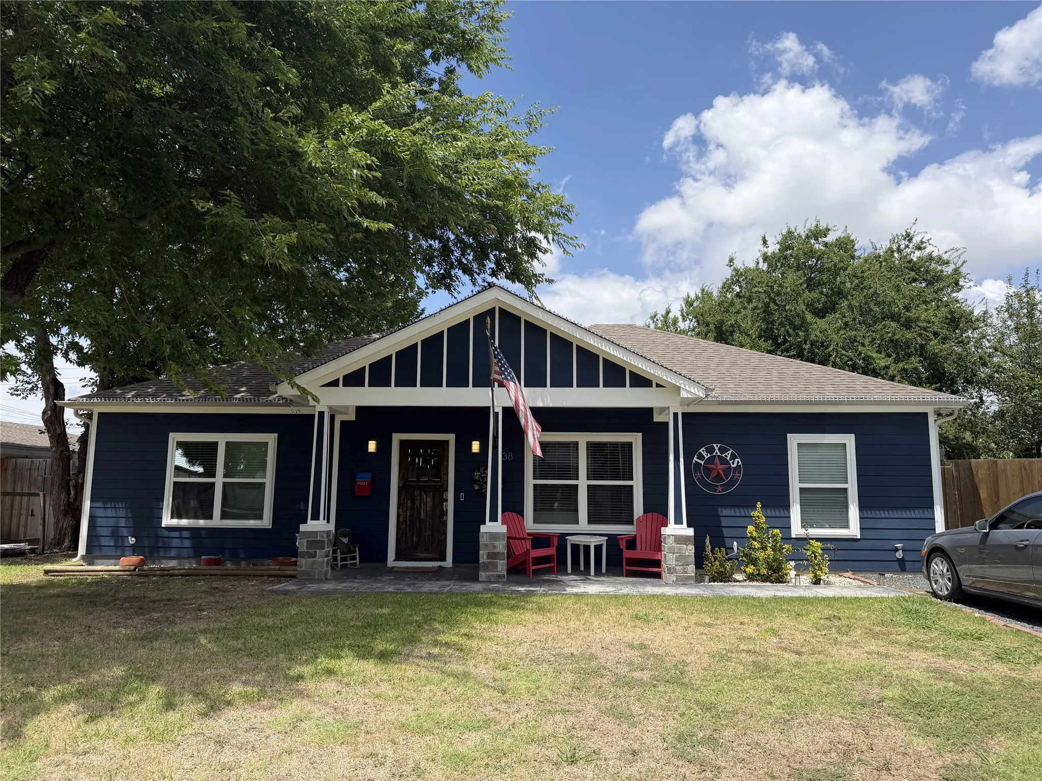 Blue siding with white trim and a gabled entry