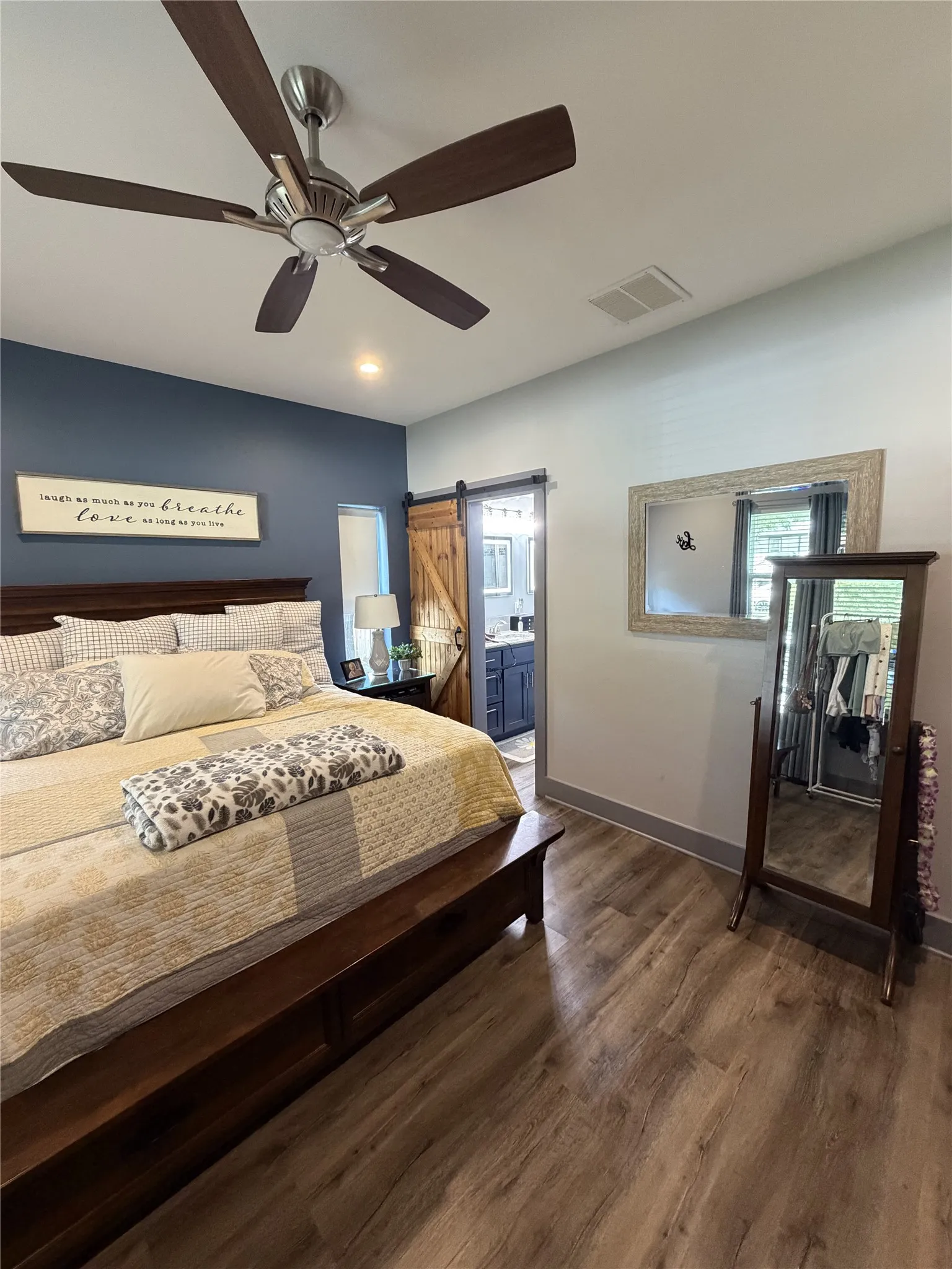 Recessed lighting, ceiling fan with wood-finish blades, accent wall, wood-finish flooring, and barn door entry