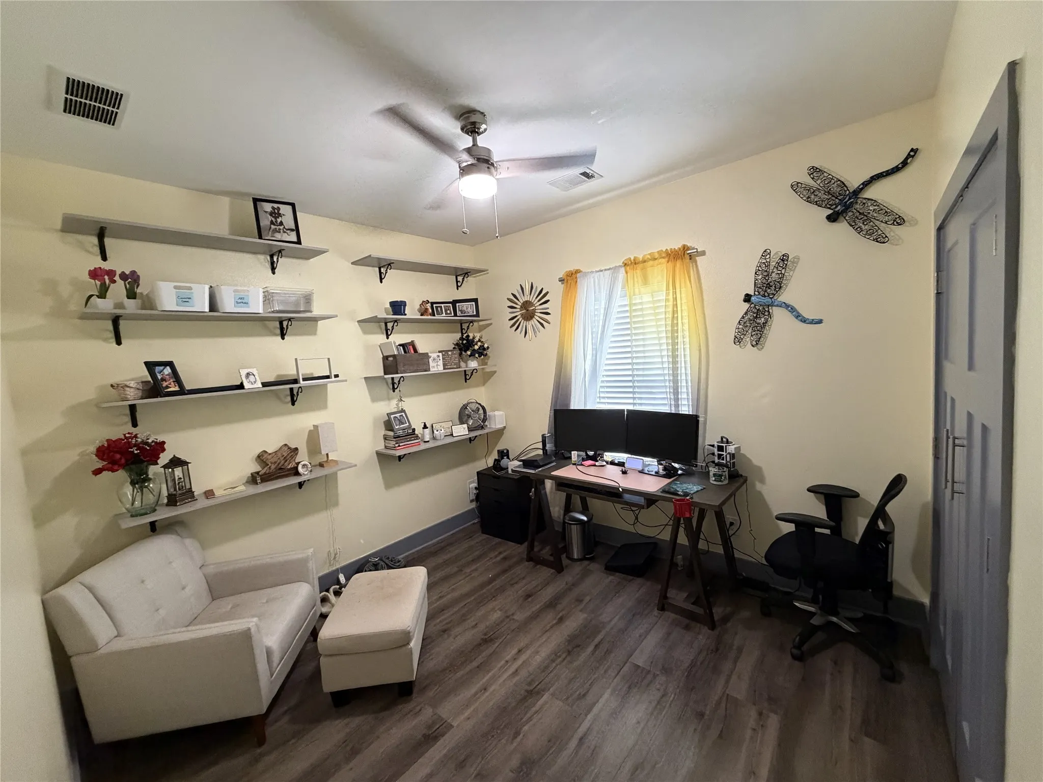Vaulted ceiling with a ceiling fan, window with blinds, wood-finish flooring, and built-in wall shelving