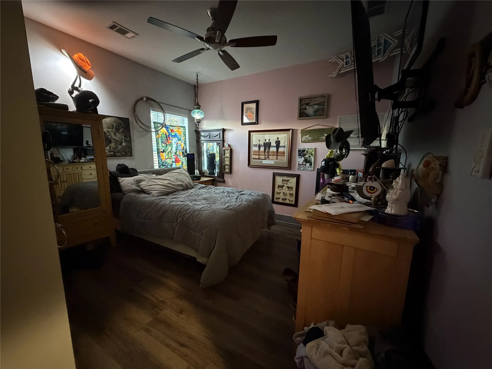Wood-finish flooring with a ceiling fan and overhead lighting