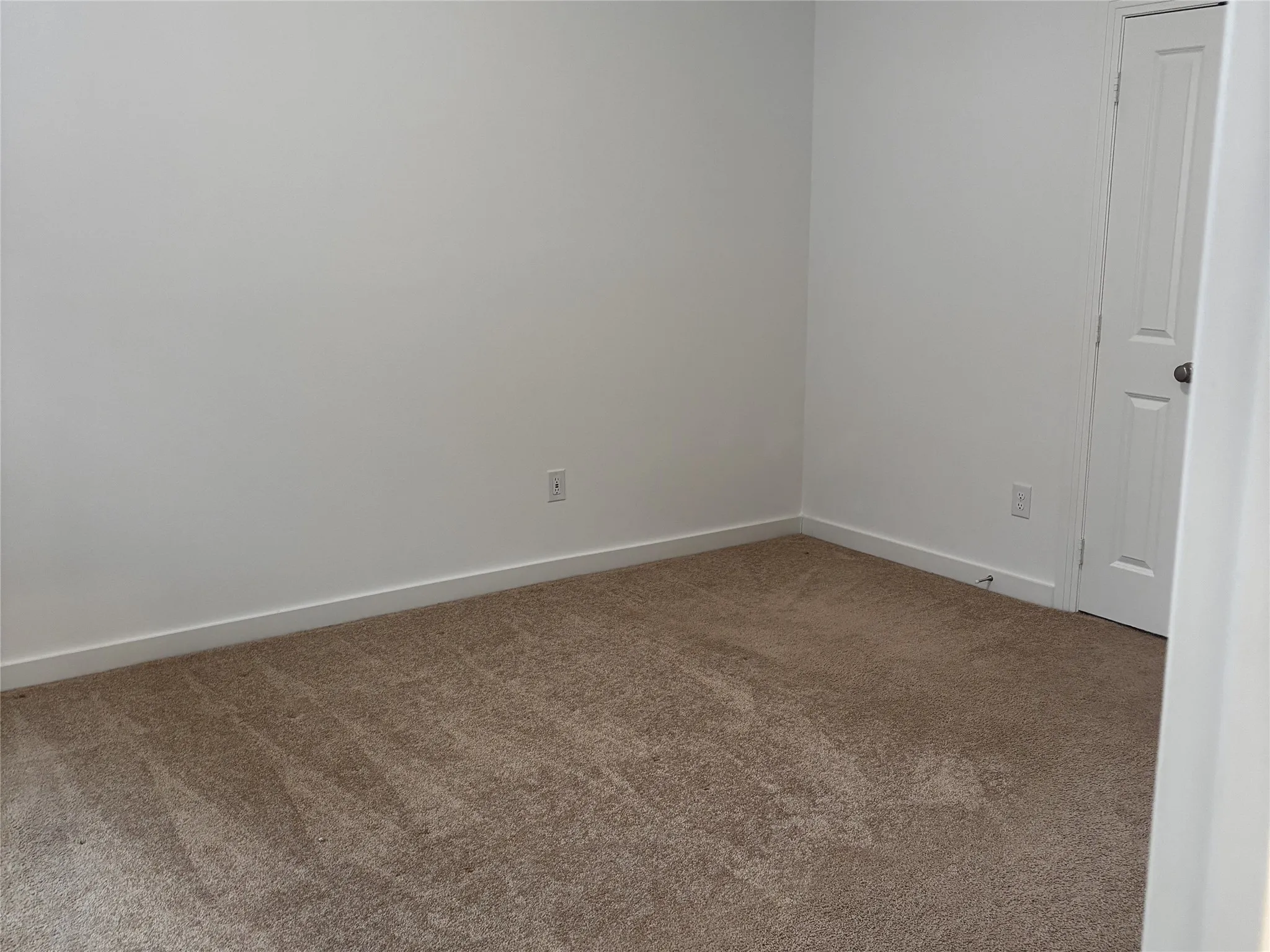Neutral wall finishes with crisp white trim, complemented by soft-tone carpeting