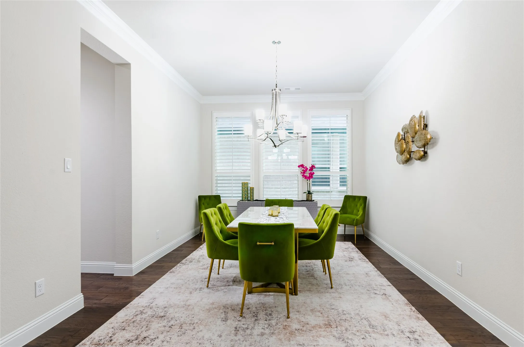 Recessed dining area featuring dark wood-finish flooring, white baseboards, and crown molding