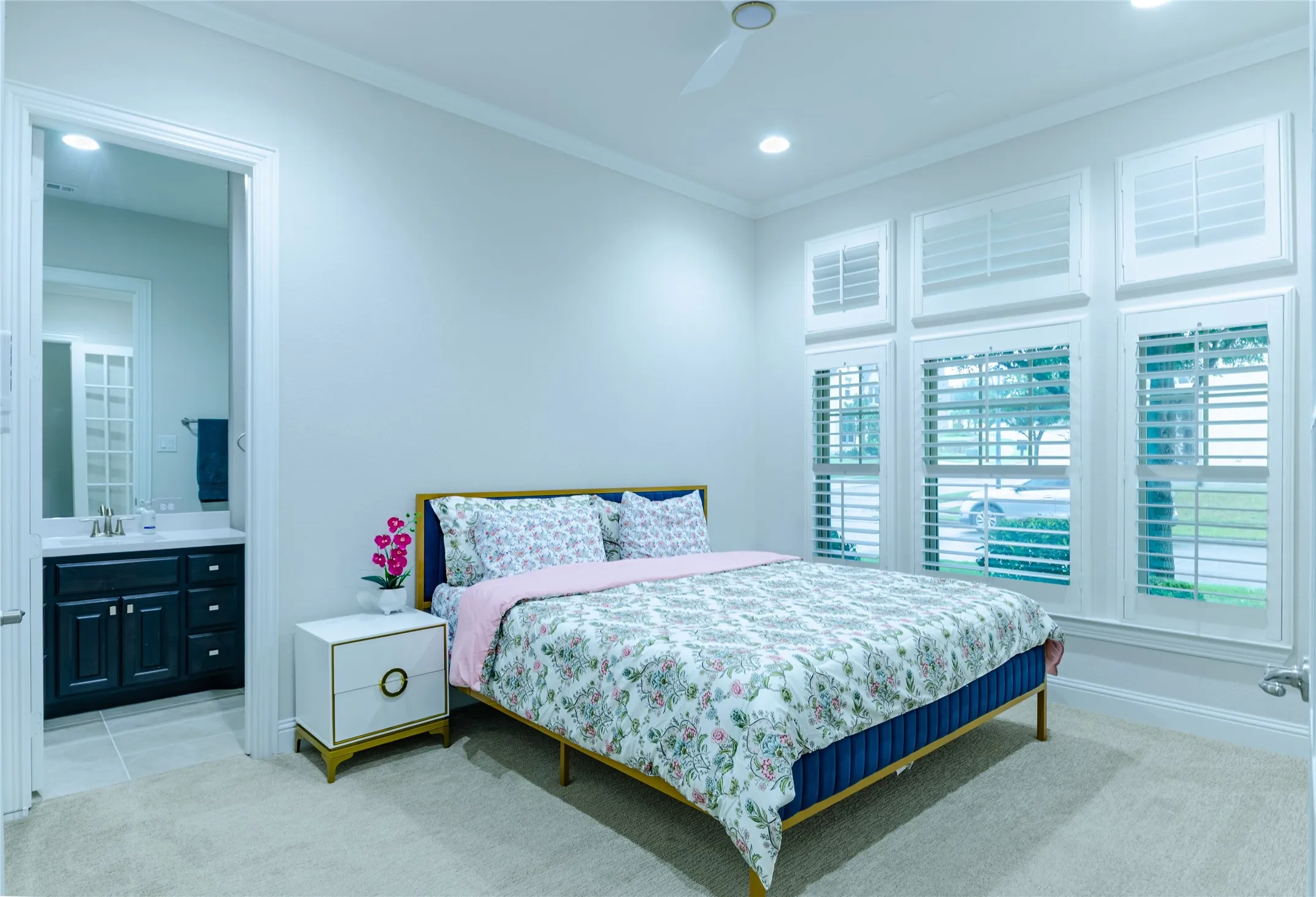 Recessed lighting illuminates this room featuring extensive window shutters