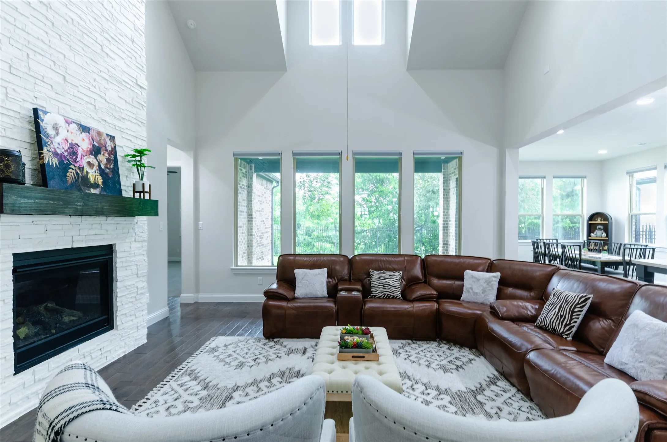 Living room featuring a fireplace with a textured stone surround and a dark wood mantel