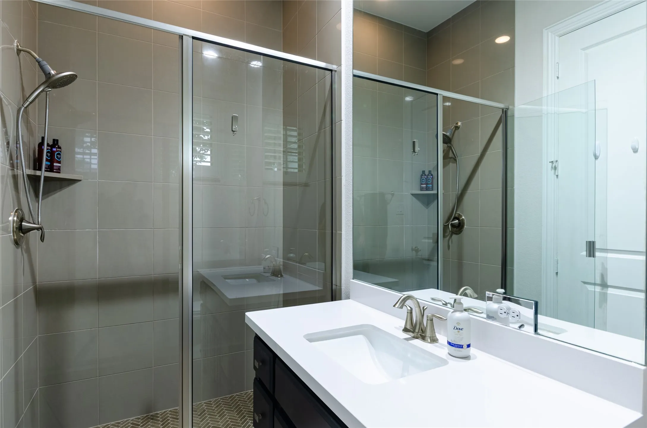 Shower enclosure featuring clear glass sliding doors and a brushed nickel showerhead