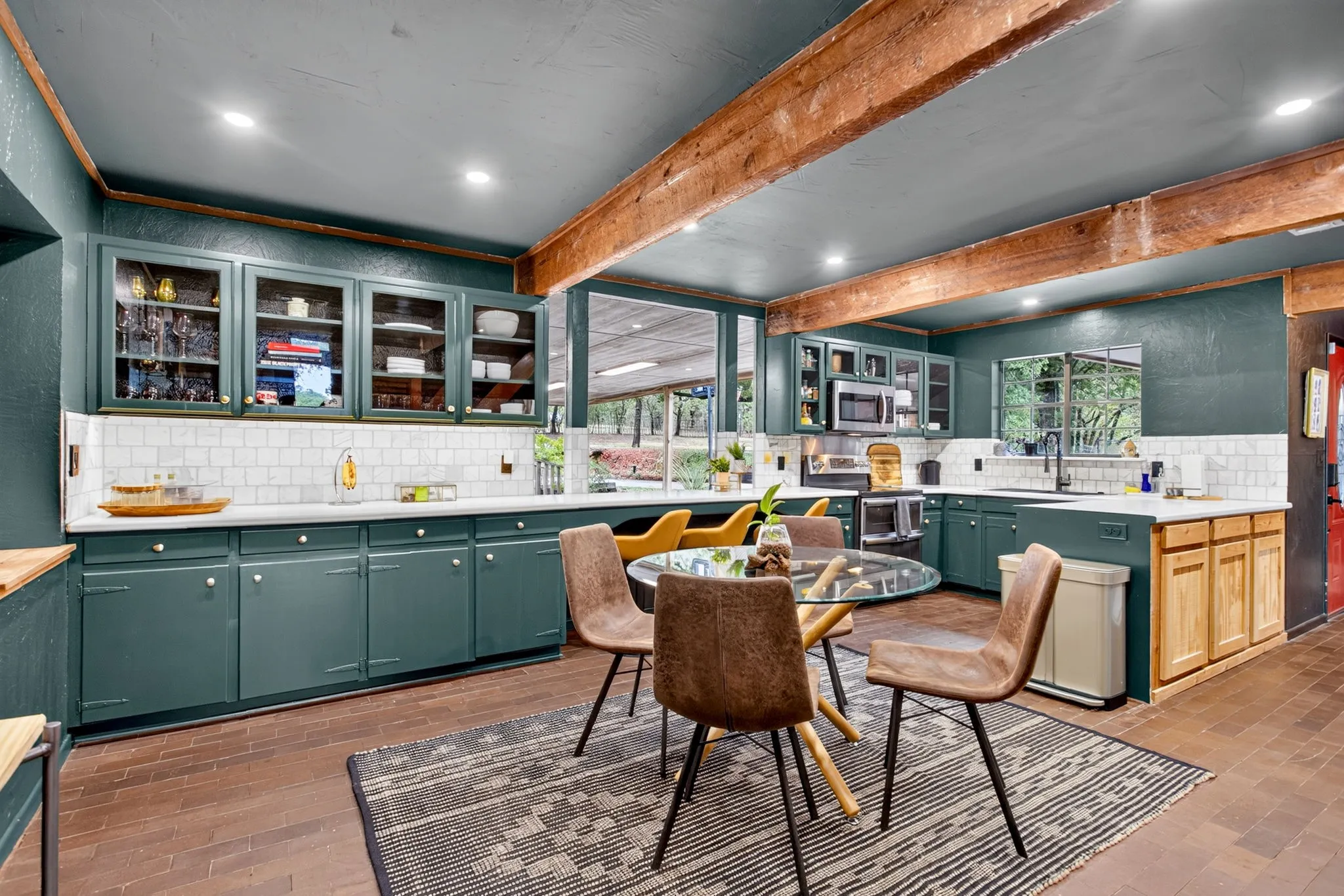 Bottle green glass-front cabinetry, rustic peninsula front, and more bold paint that makes everything POP.