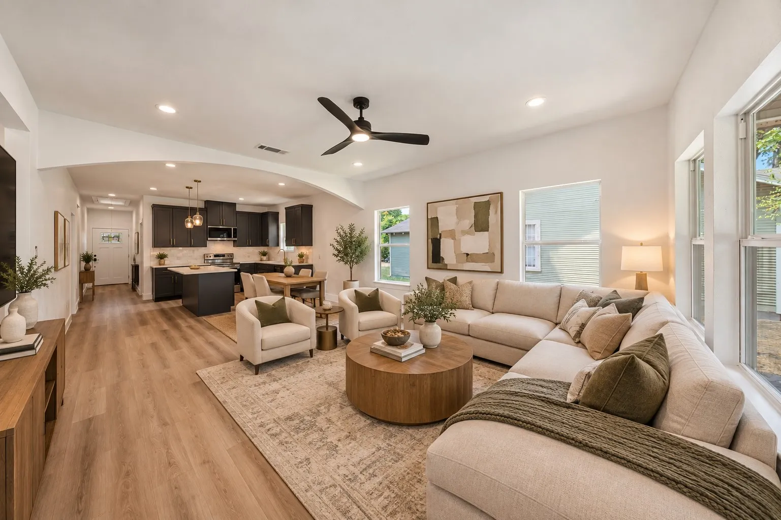 Vrirtually staged open space with wood-finish flooring, recessed lighting, and an arched entryway
