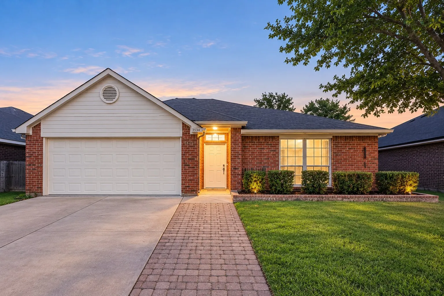 Brick exterior with white siding accents and a dark shingle roof