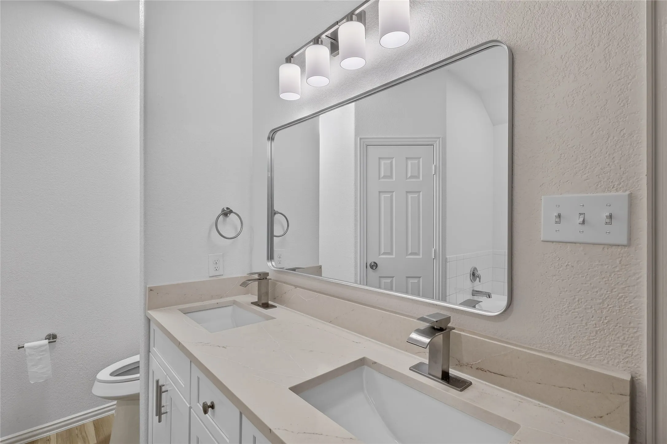 Dual vanity with integrated sinks, light-toned countertop, and brushed nickel fixtures