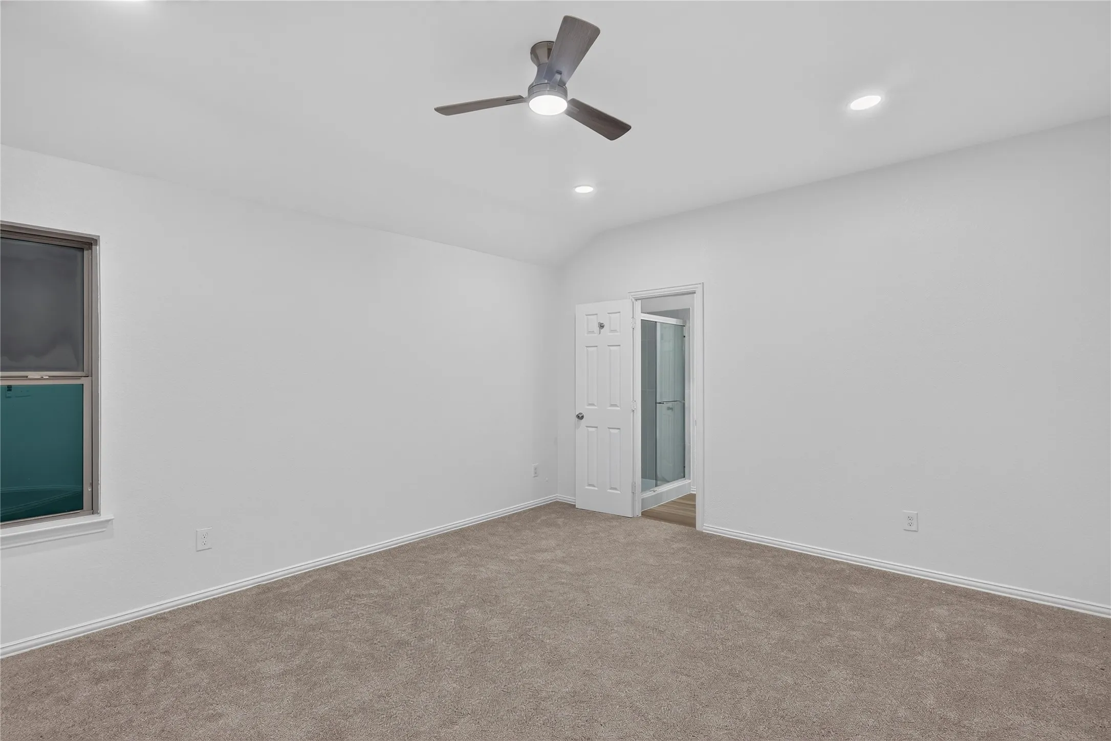 Carpeted room with a ceiling fan, recessed lighting, and a window