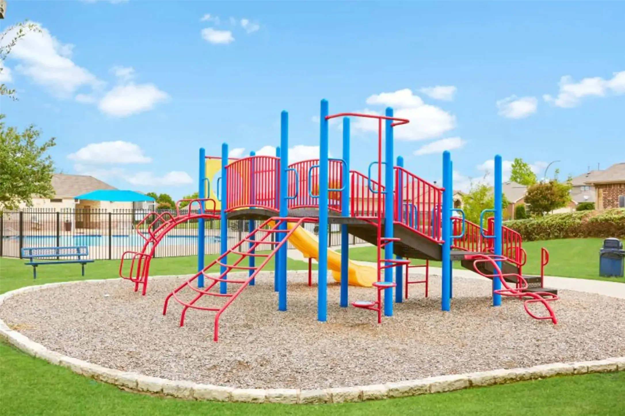 Playground featuring multiple slides, climbing structures, and protective ground cover