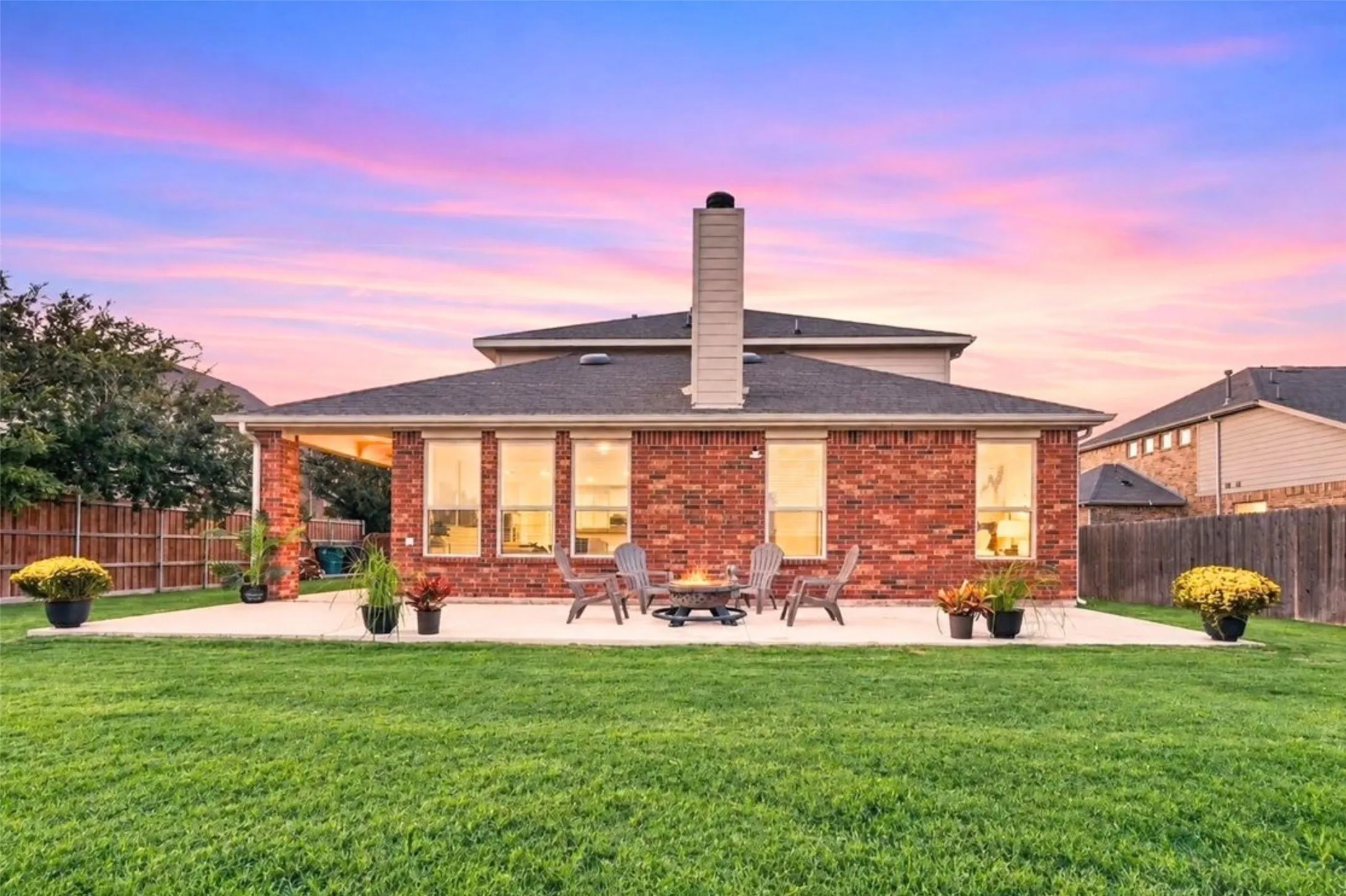 Expansive lawn featuring a concrete patio, brick exterior, and covered outdoor area