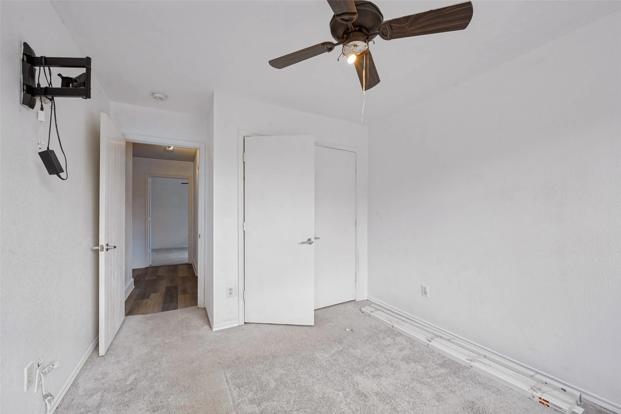 Wall-to-wall carpeting and a ceiling fan with integrated lighting