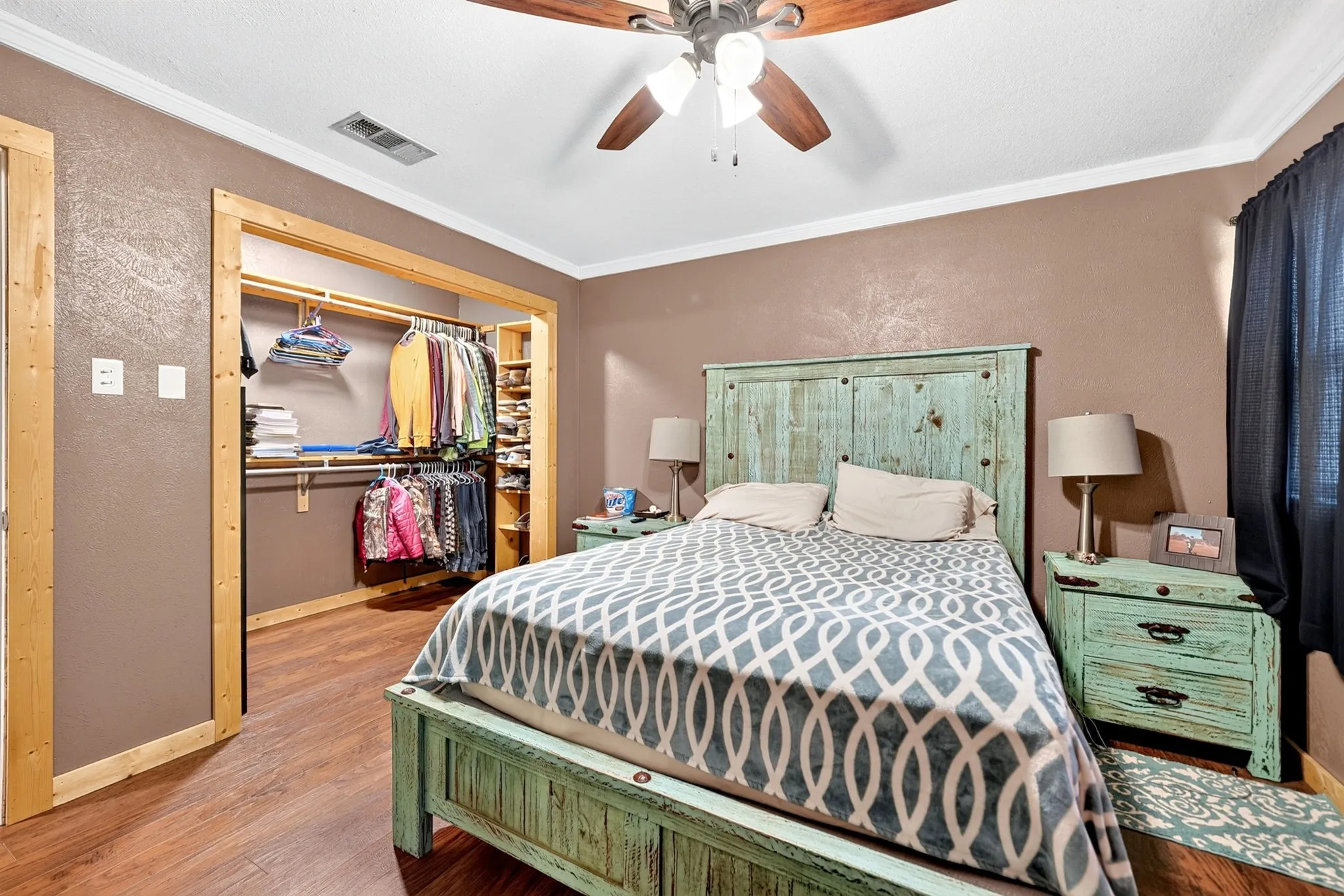 Wood-finish flooring throughout, ceiling fan with integrated lighting, and crown molding