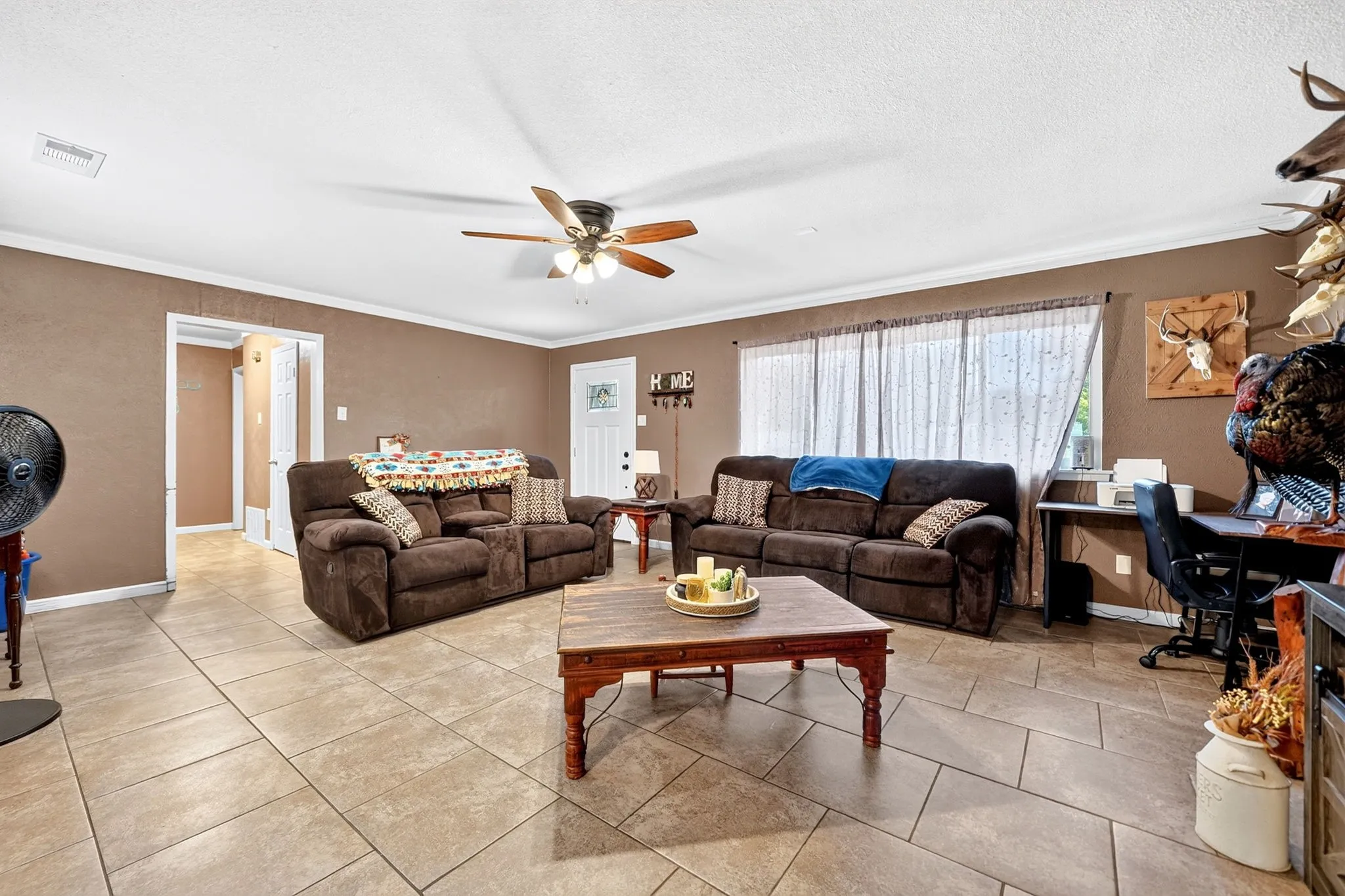 Recessed lighting, ceiling fan, tile flooring, crown molding, and a paneled door