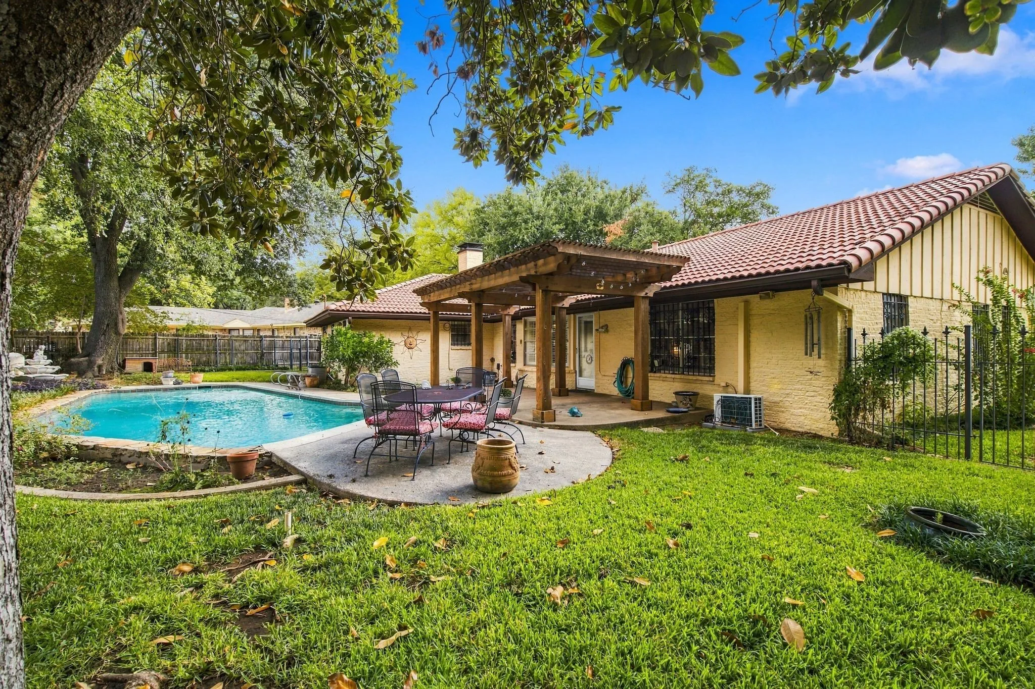 Backyard oasis featuring a swimming pool, concrete patio, and a wood pergola
