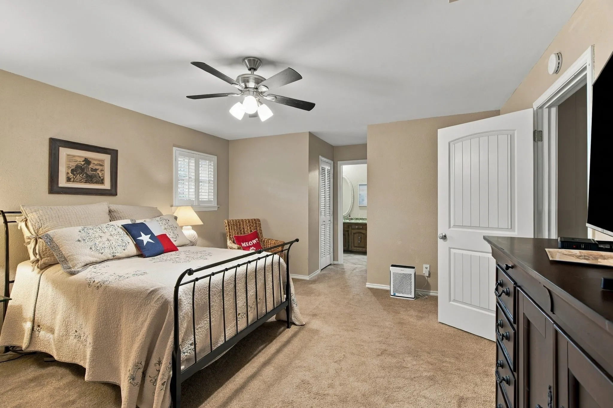 Carpet flooring, ceiling fan with integrated lighting, white paneled door, and plantation shutters