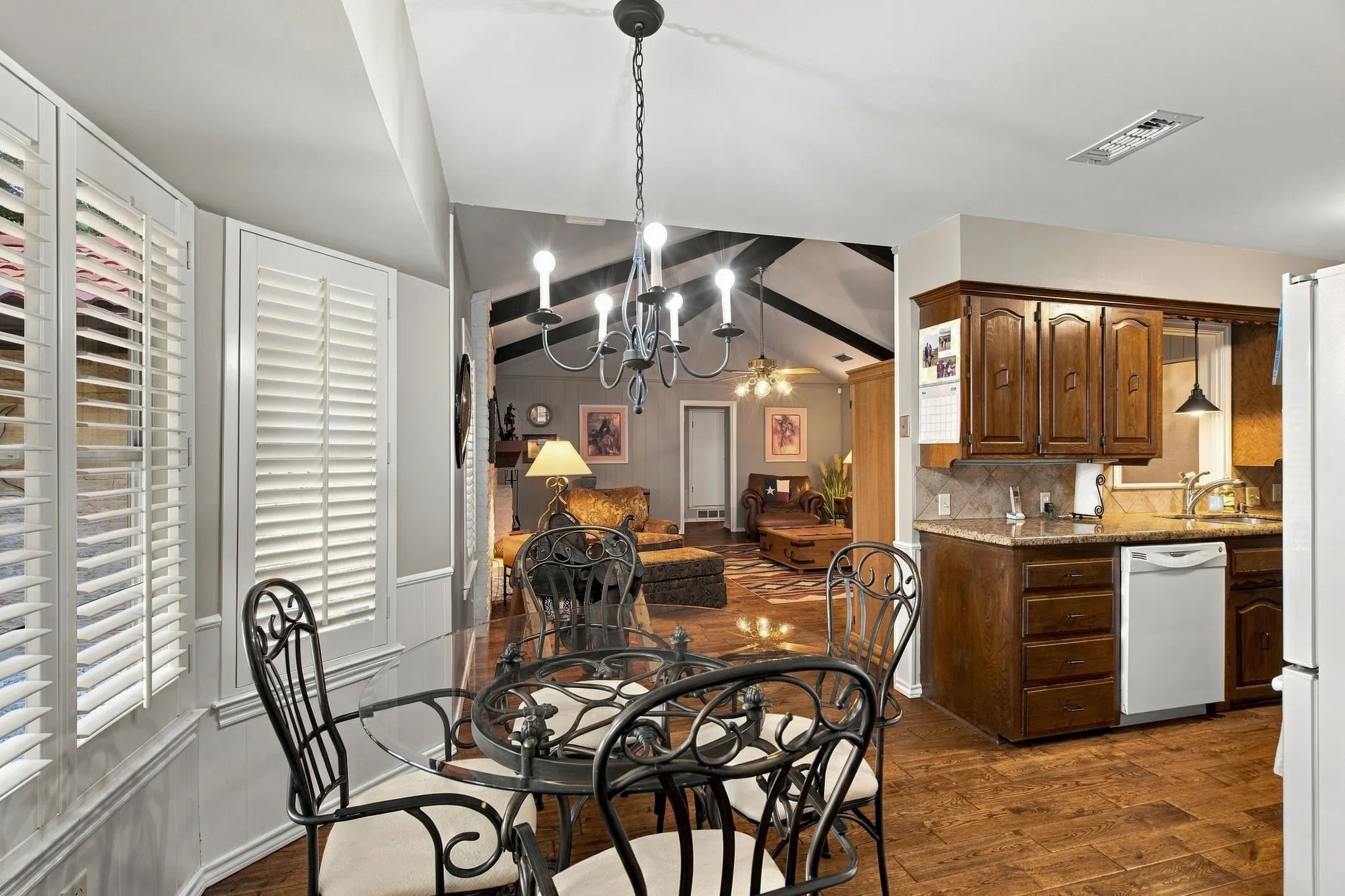 Kitchen with wood-finish flooring, granite countertops, and wood cabinetry