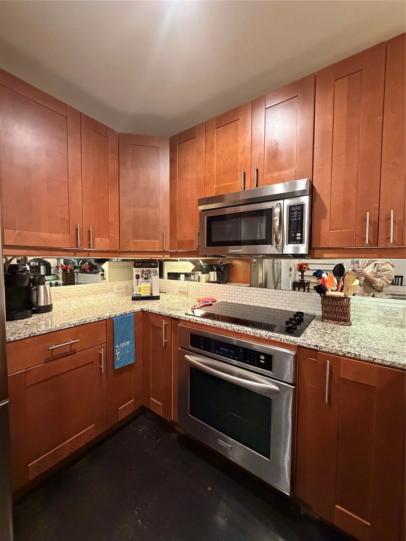 Kitchen featuring wood cabinetry, light-toned countertops, a tile backsplash, and stainless steel appliances