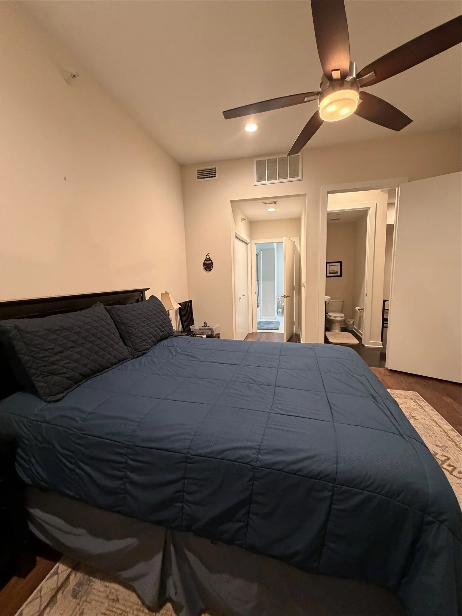 Sloped ceiling with recessed lighting, ceiling fan, wood-finish flooring, and a built-in air vent