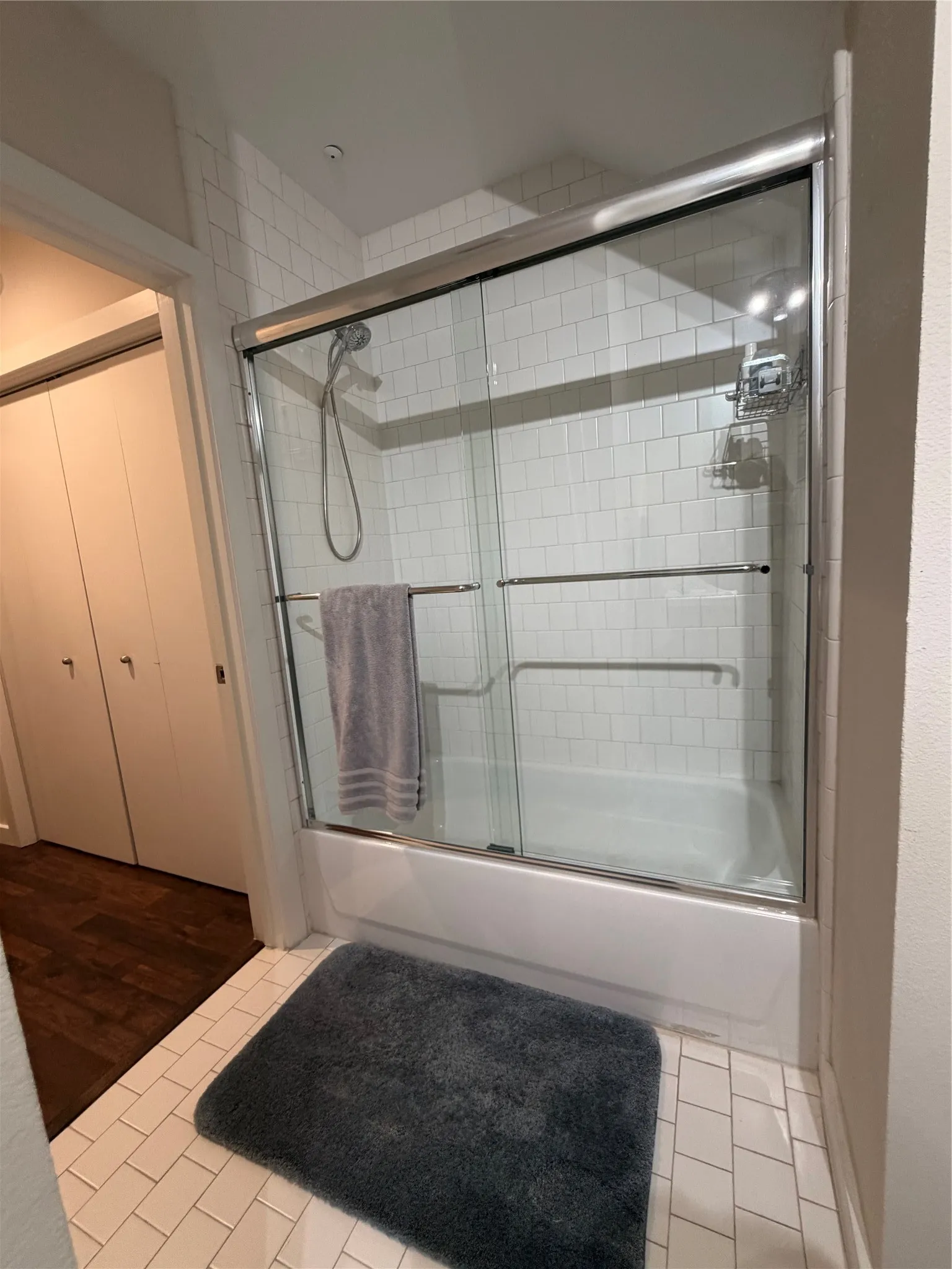 Tub and shower combination with subway tile surround and glass sliding doors