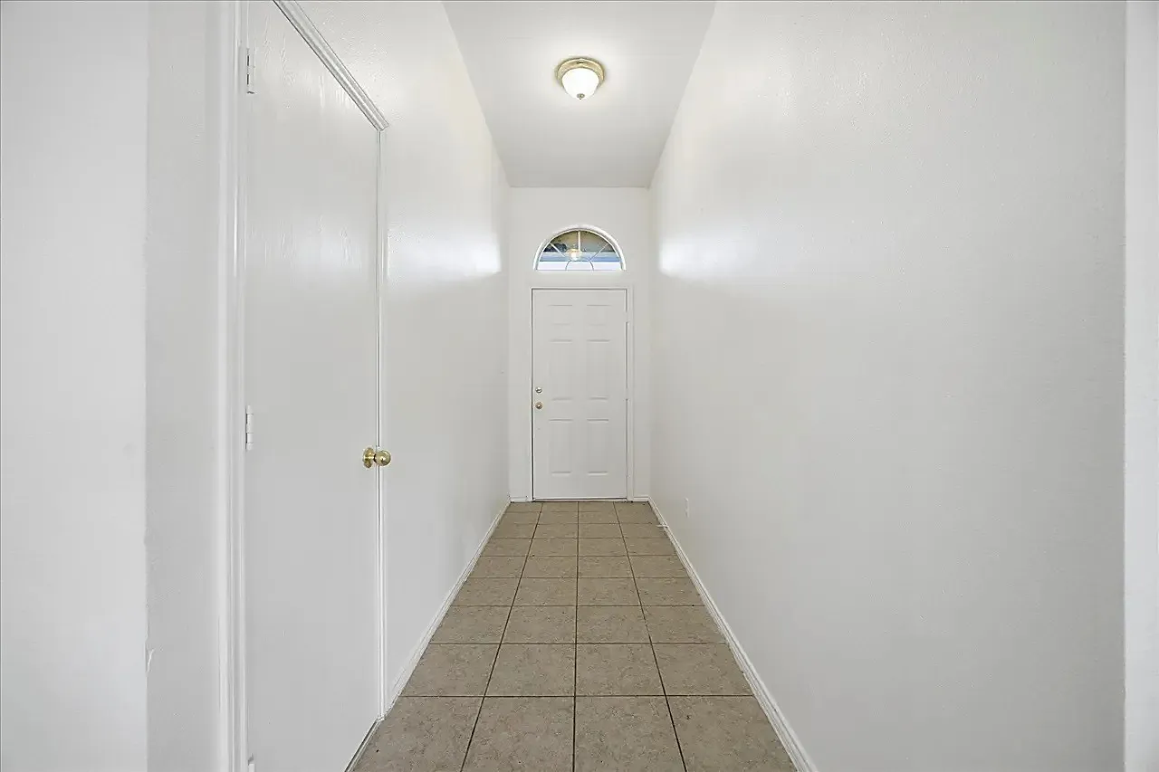 Entryway featuring a white door with an arched transom, recessed ceiling light, and tile flooring