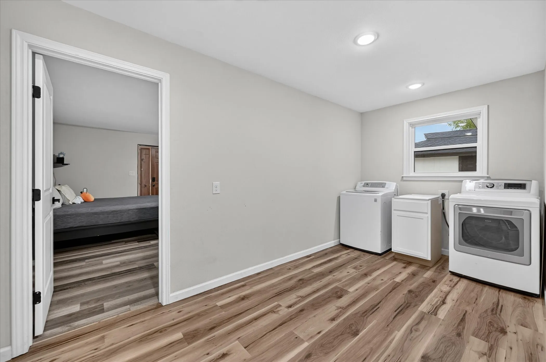 Wood-finish flooring, recessed lighting, and a window with white trim