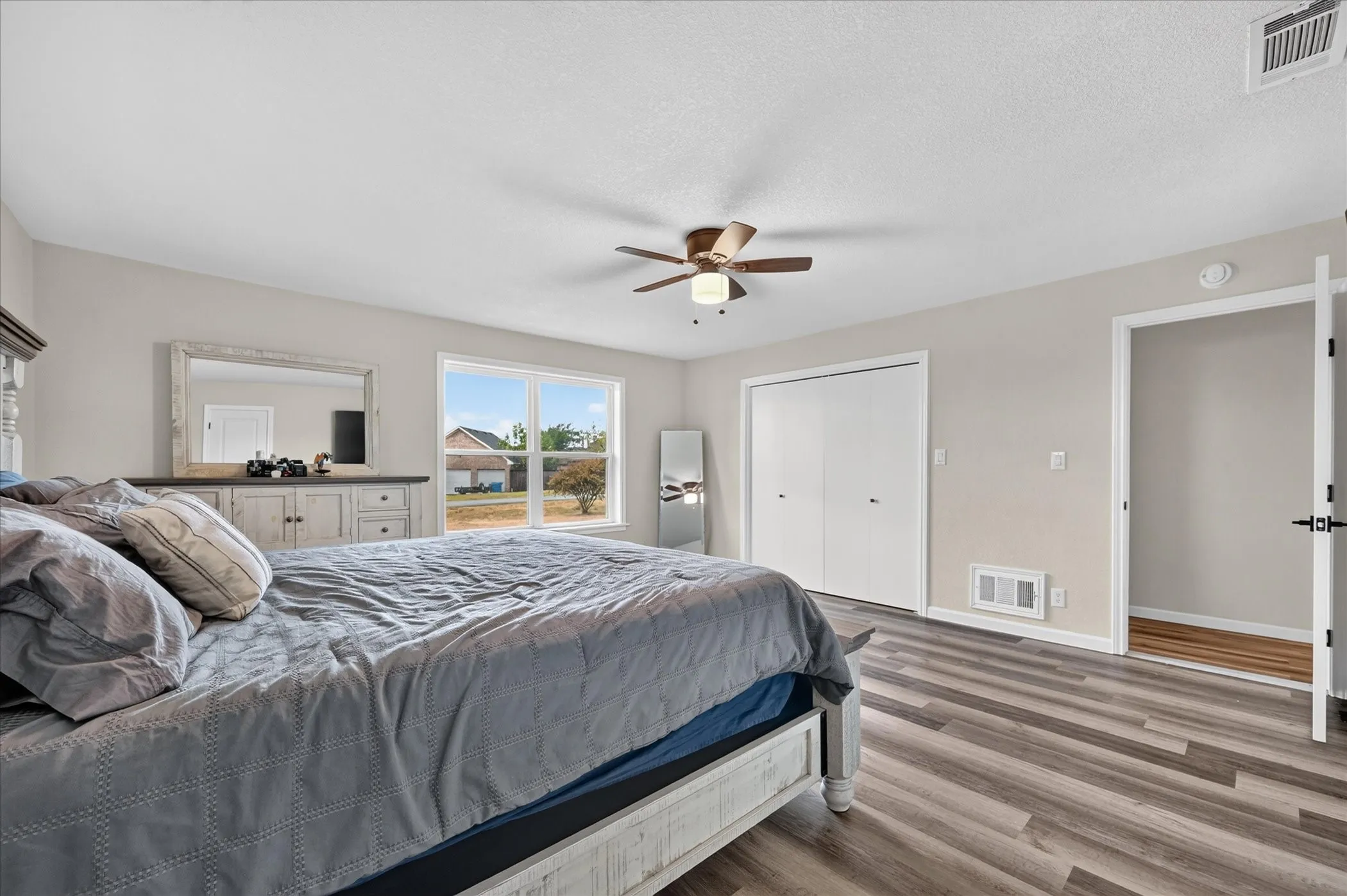 Wood-finish flooring, white walls, and a ceiling fan with integrated lighting