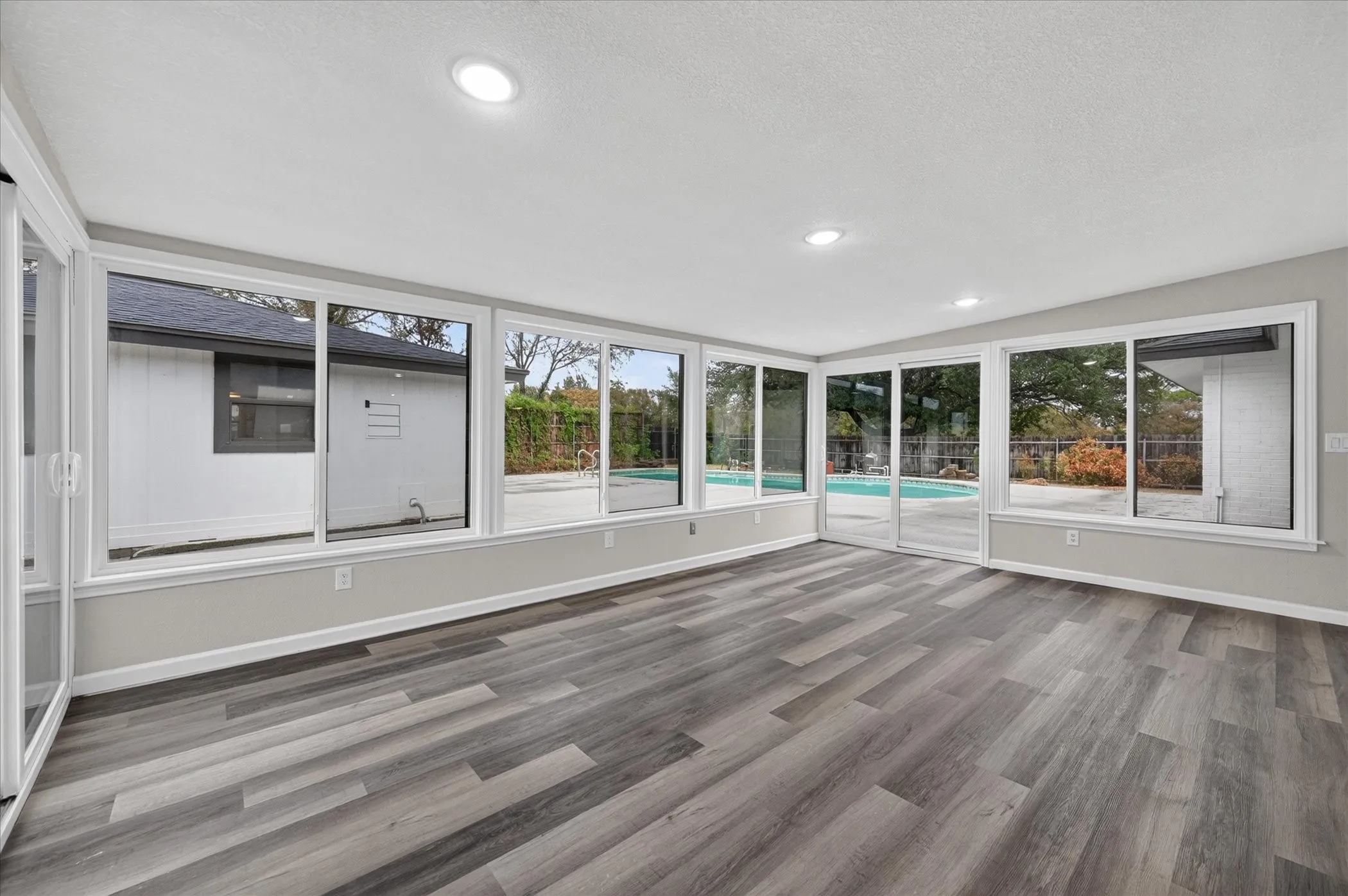 Wood-finish flooring, recessed lighting, and expansive windows
