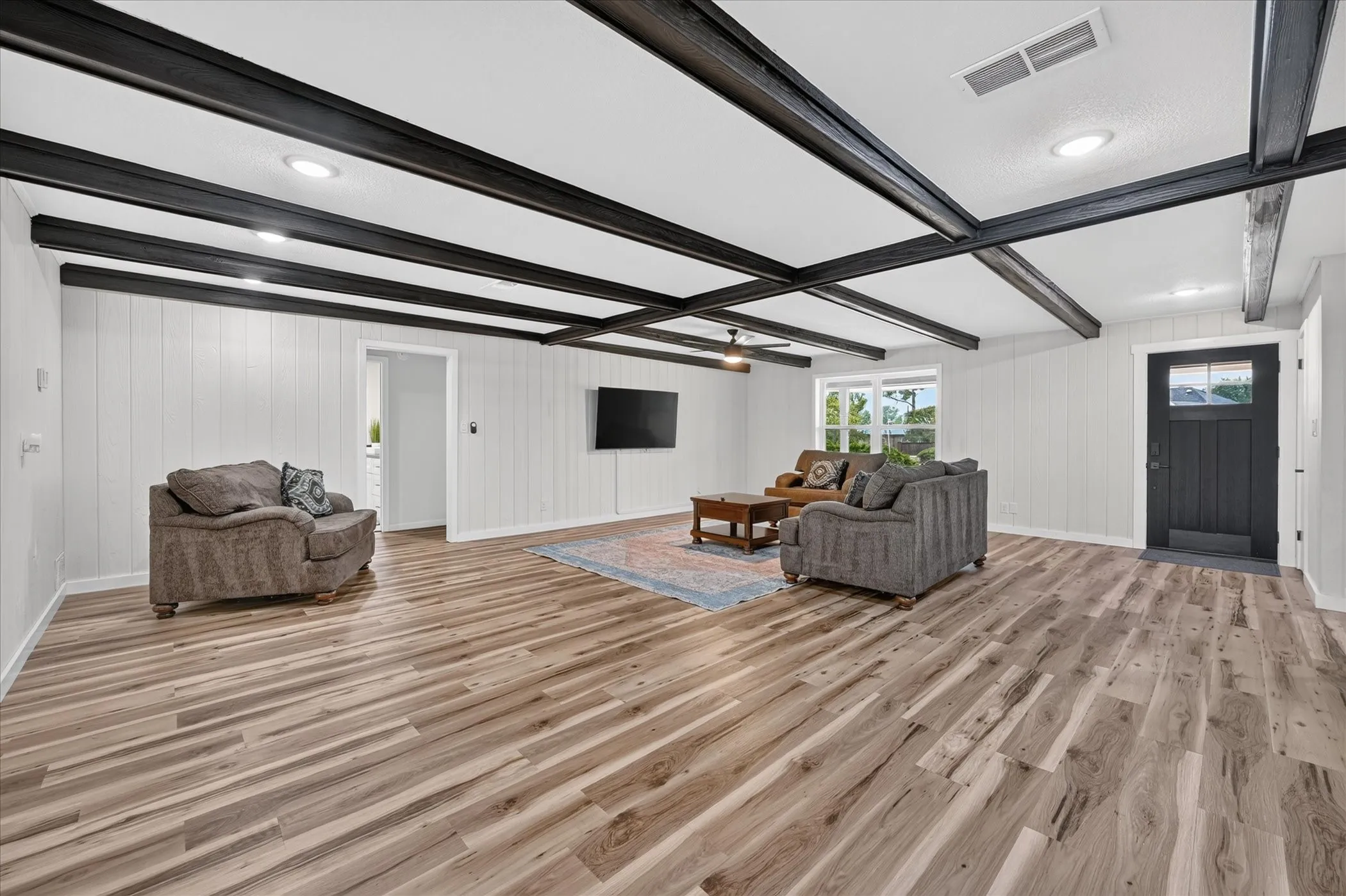 Vaulted ceiling with dark exposed beams and recessed lighting