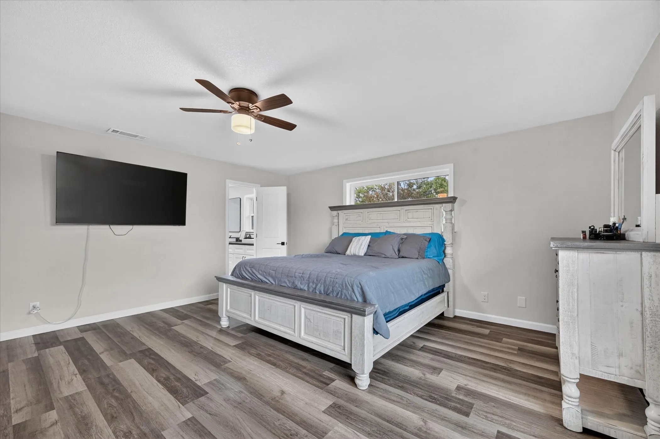 Wood-finish flooring, ceiling fan, and white trim