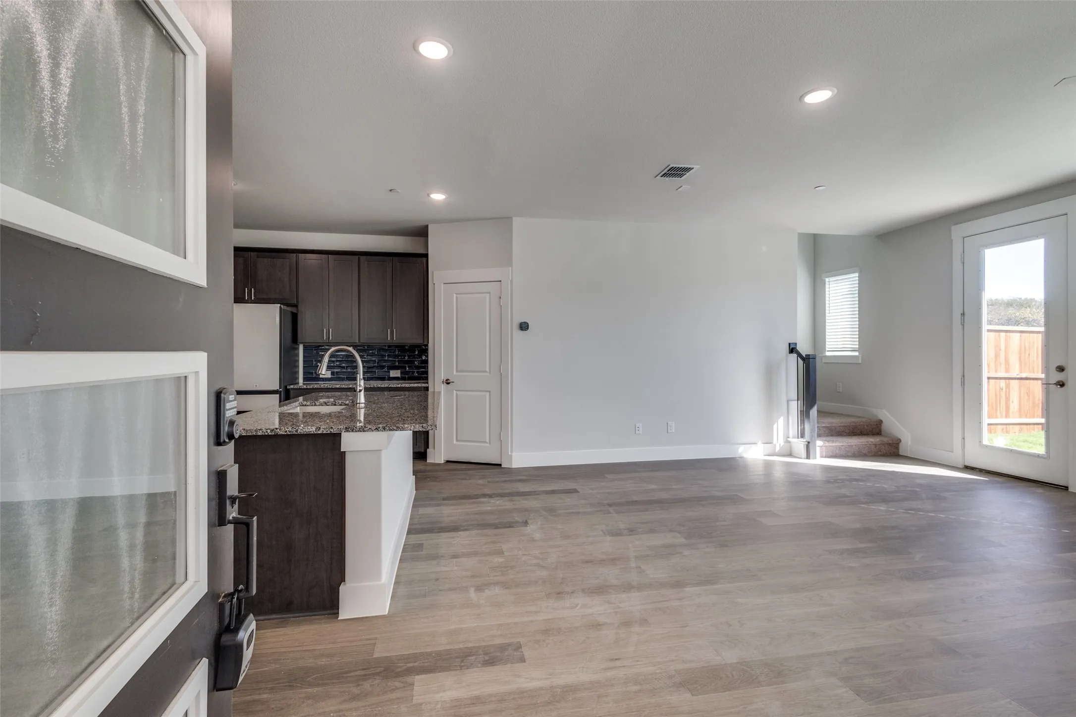 Living room with light hardwood / wood-style flooring and sink