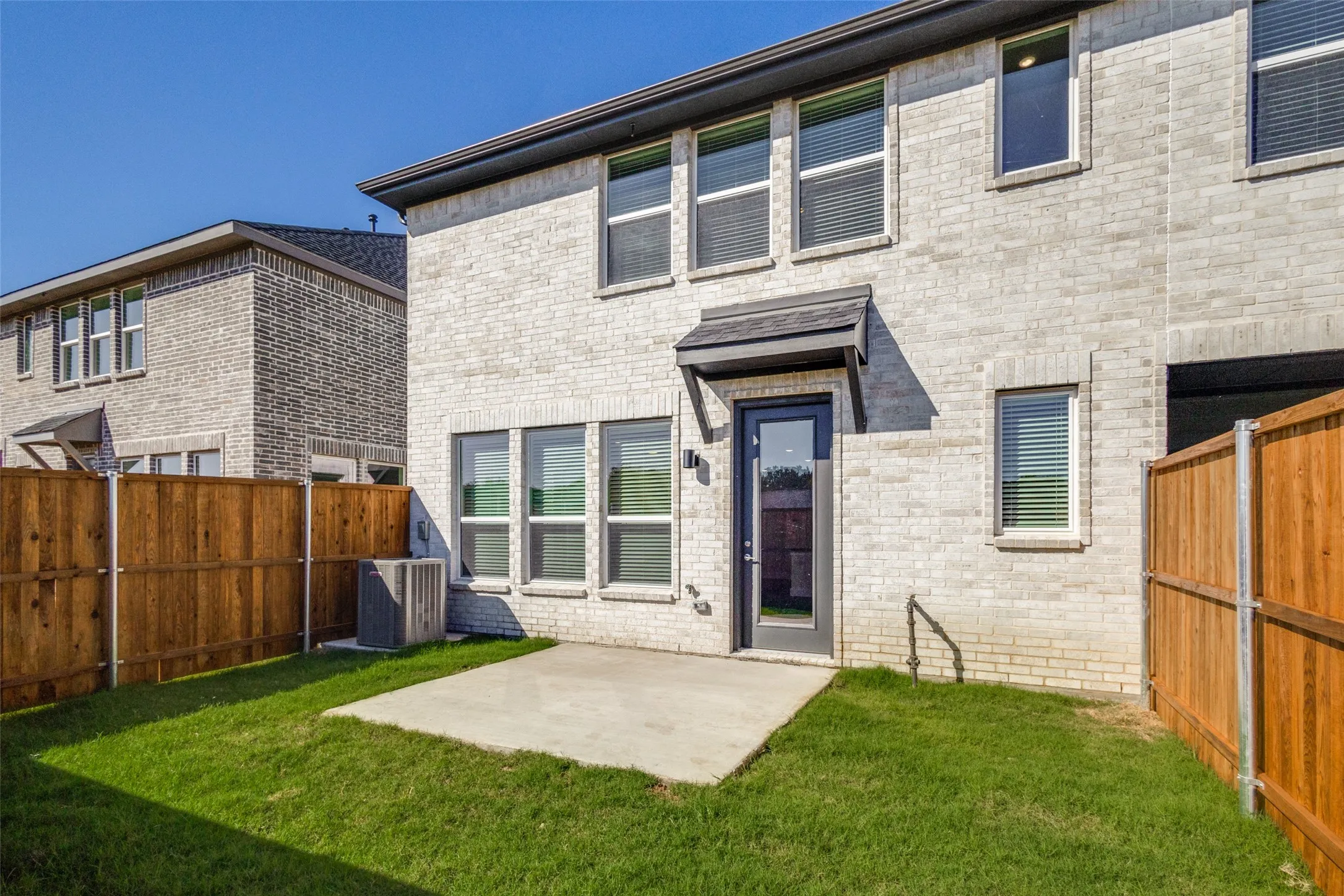 Back of house featuring a lawn, central air condition unit, and a patio area
