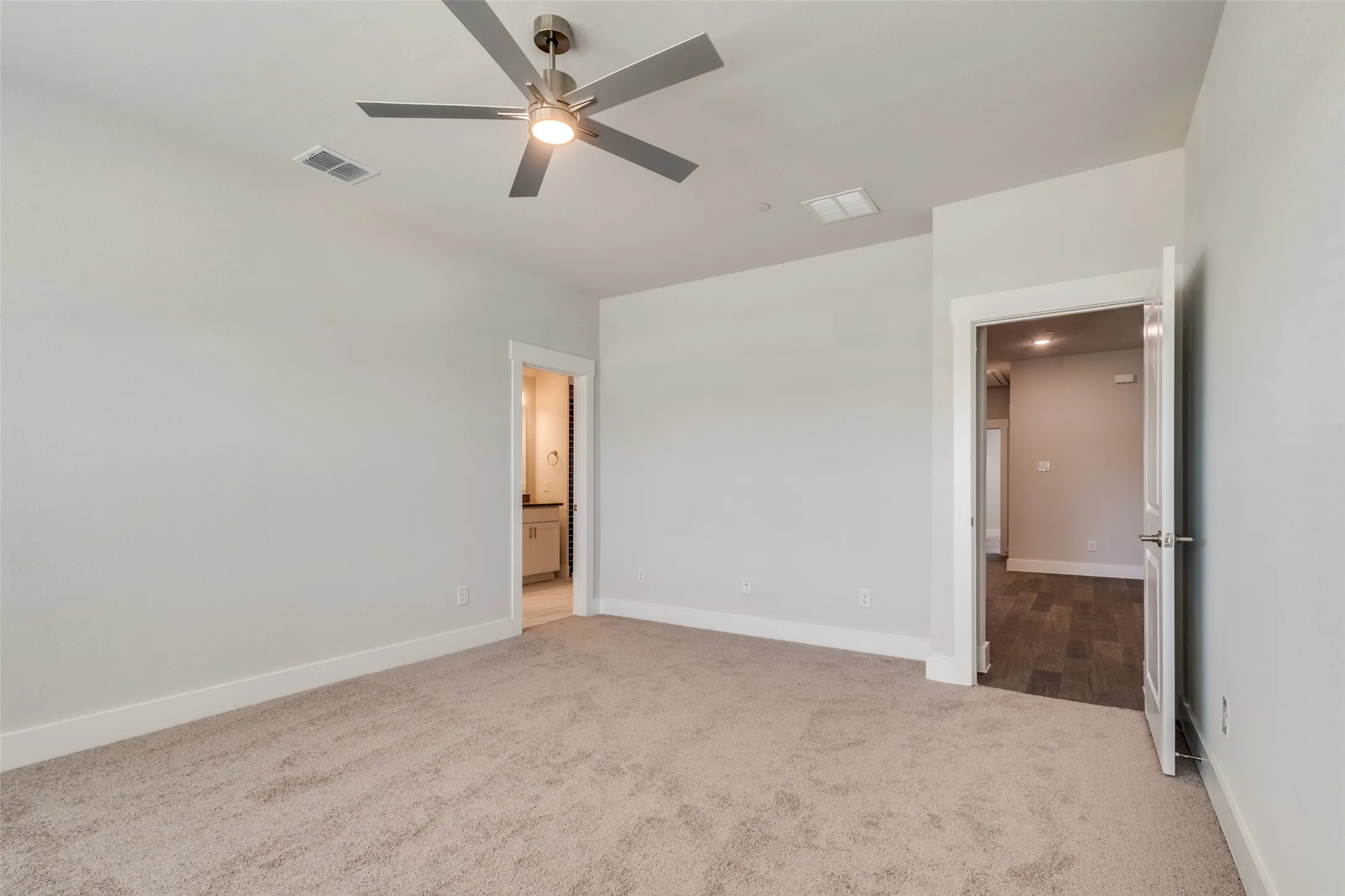 Unfurnished bedroom featuring ceiling fan and light colored carpet