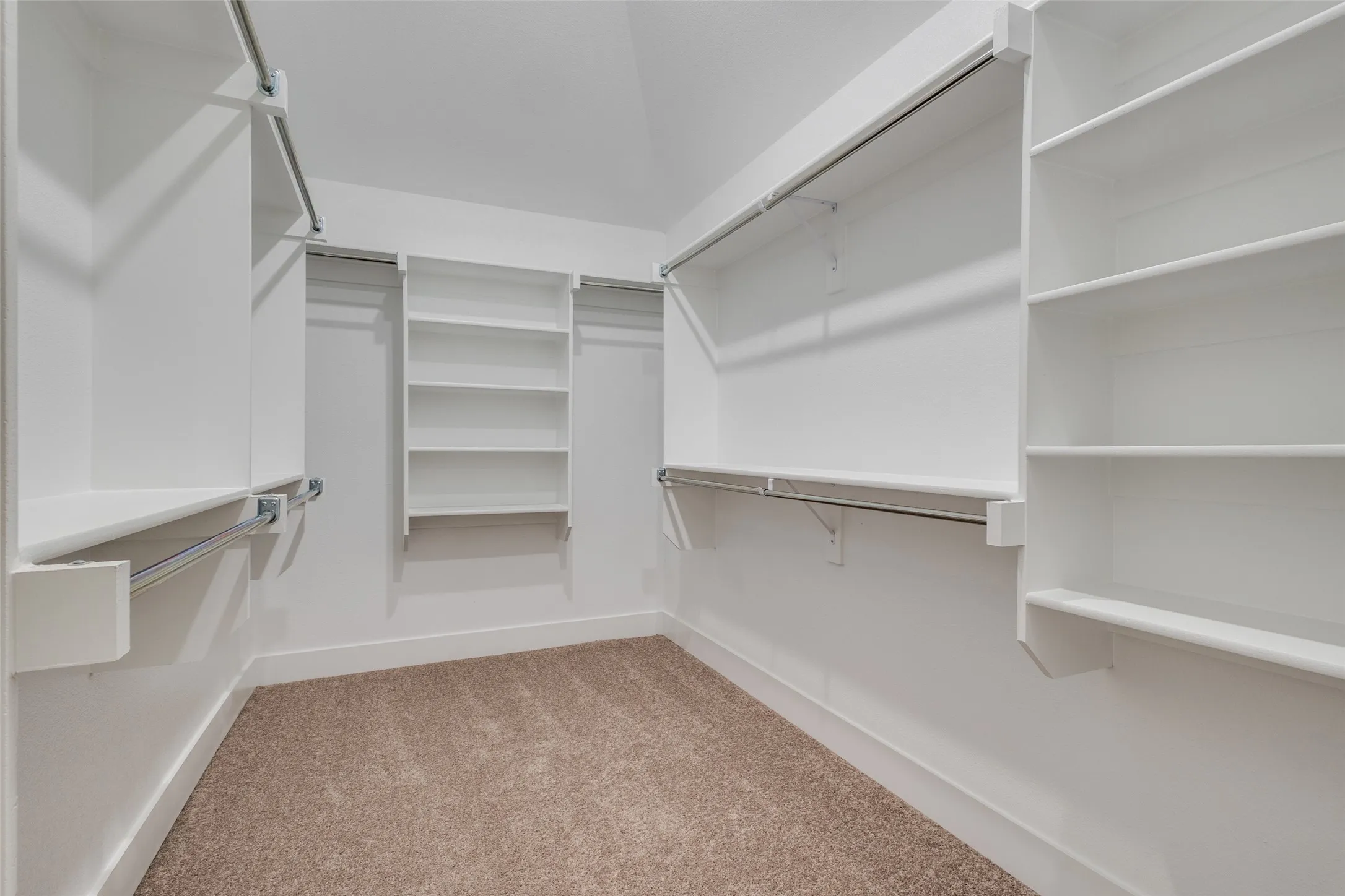 Spacious closet featuring light colored carpet