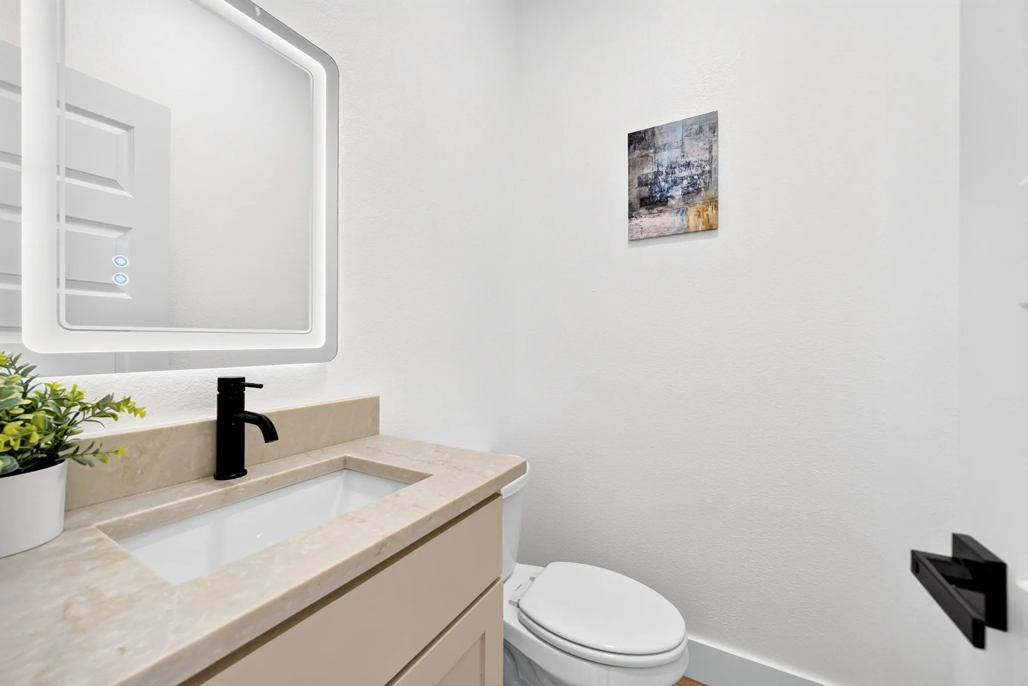 Integrated vanity with a rectangular sink, light-toned countertop, and matte black faucet