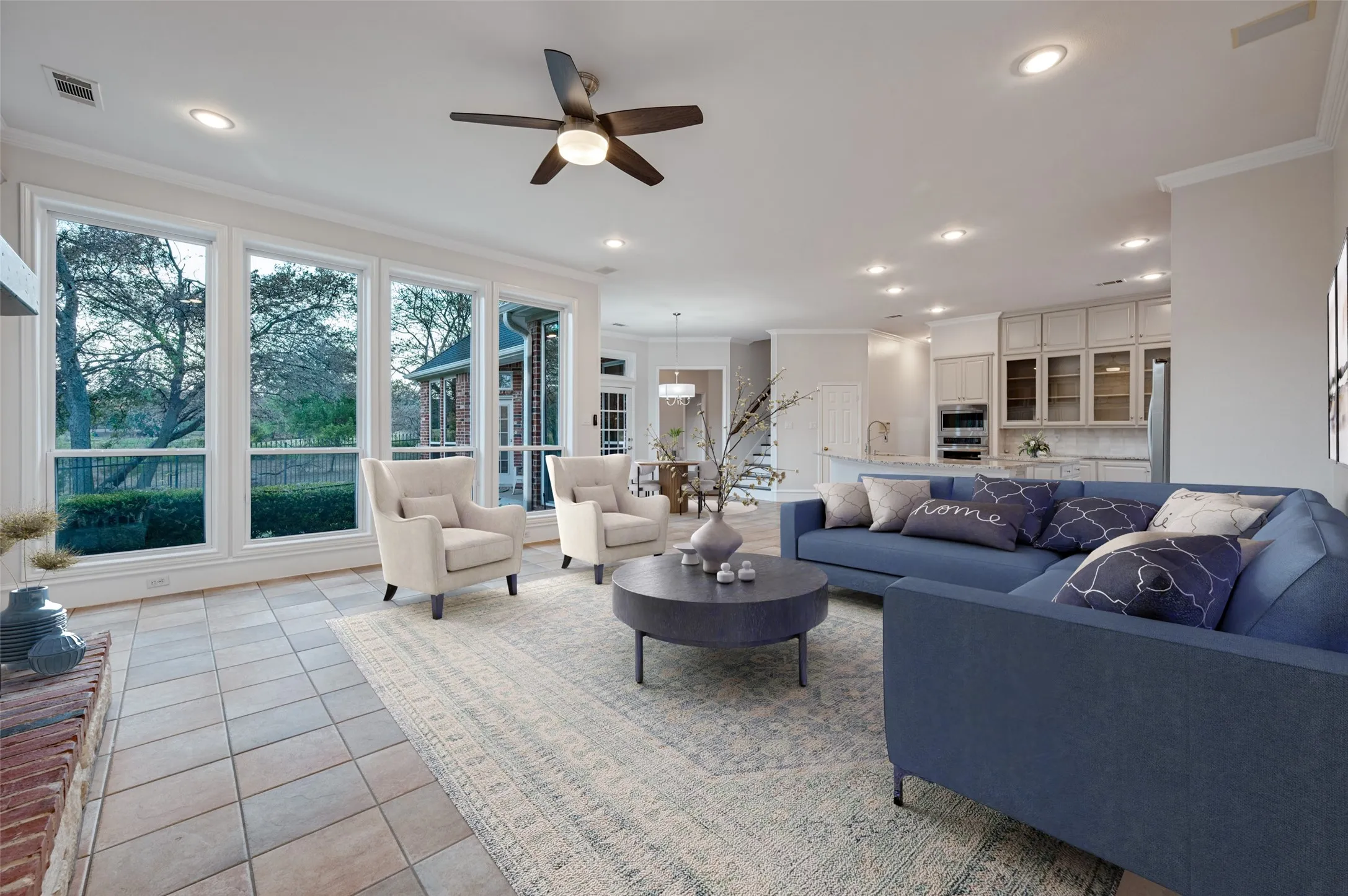 Virtually staged family room showcasing a wood-burning fireplace, new windows along the back of the home, and new light fixtures