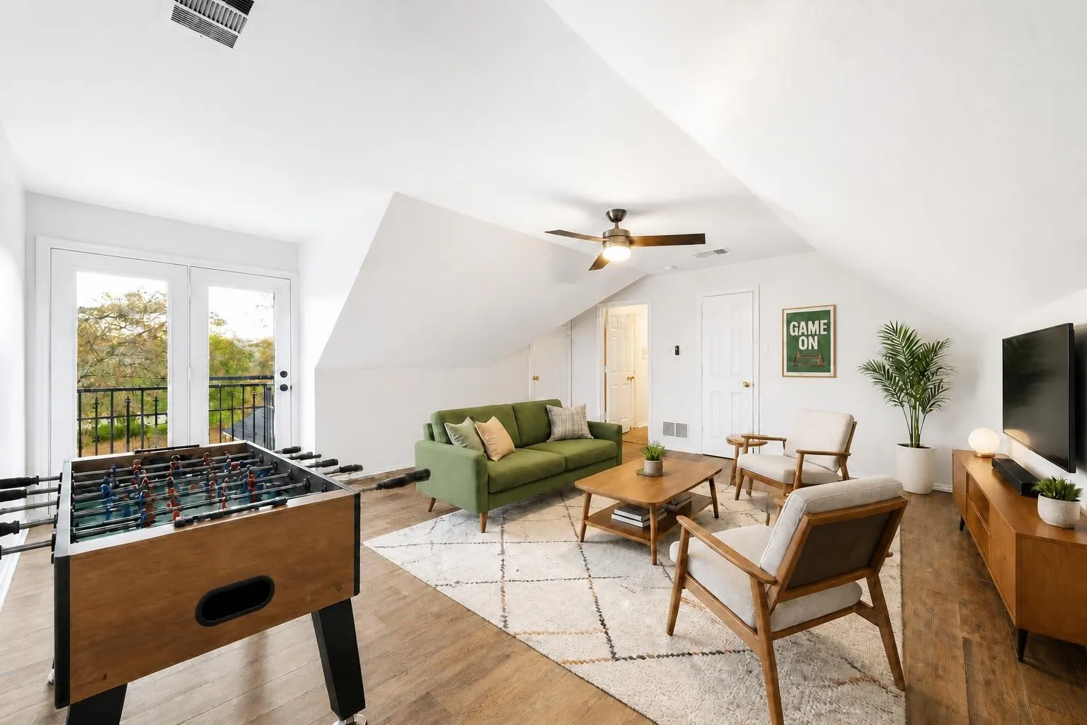 Upstairs virtually staged game room. This room is an additional bedroom 3 as it features a closet, windows, and an exterior door with it's own balcony. The entire home has also been freshly painted