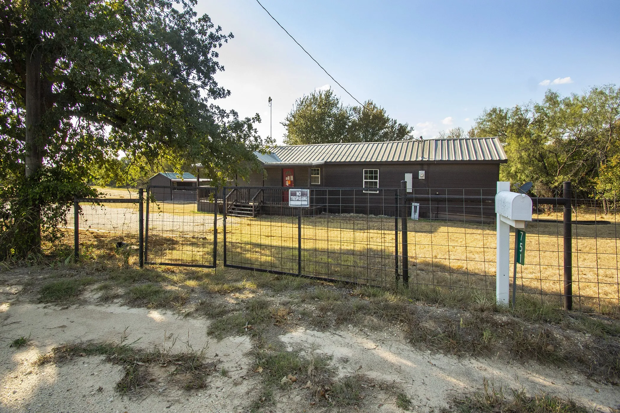 Property featuring a dark-toned exterior, metal roof, and a fenced perimeter