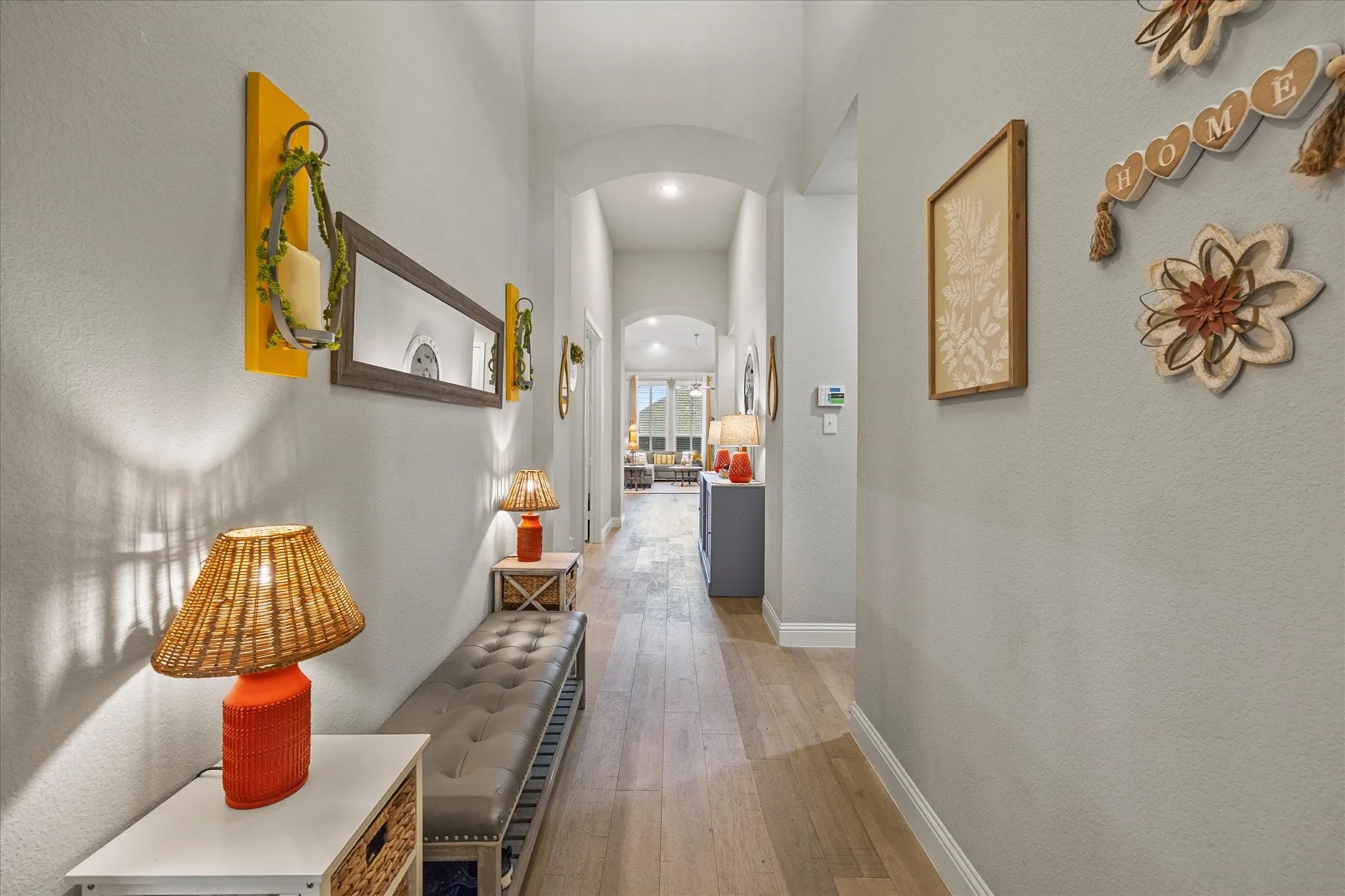 Hallway featuring wood-finish flooring, light gray wall paint, and arched doorways