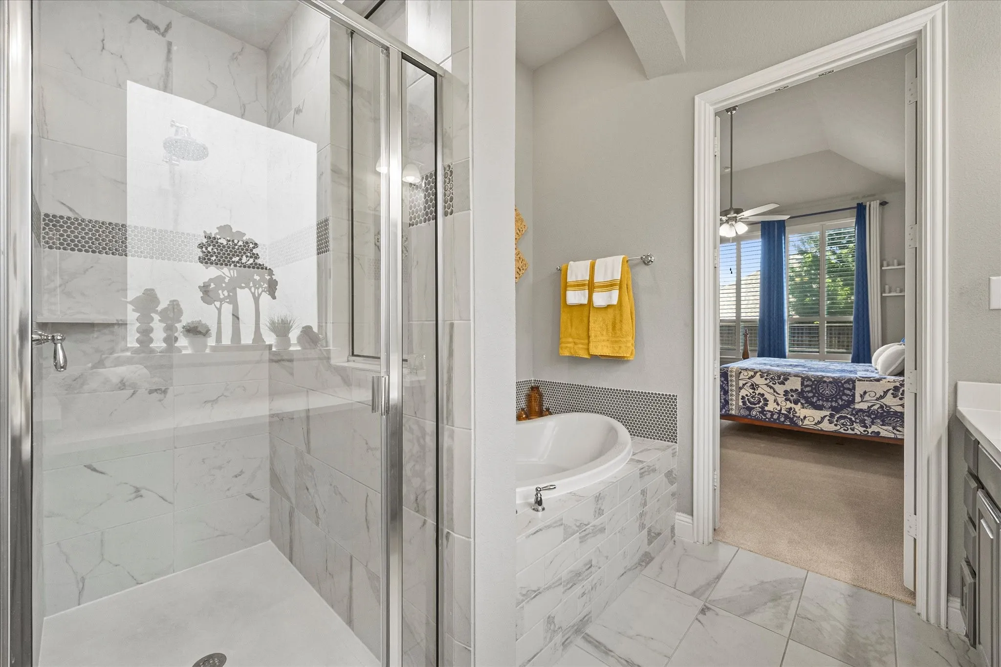 Glass-enclosed shower with white tiled walls, separate soaking tub, and tile flooring