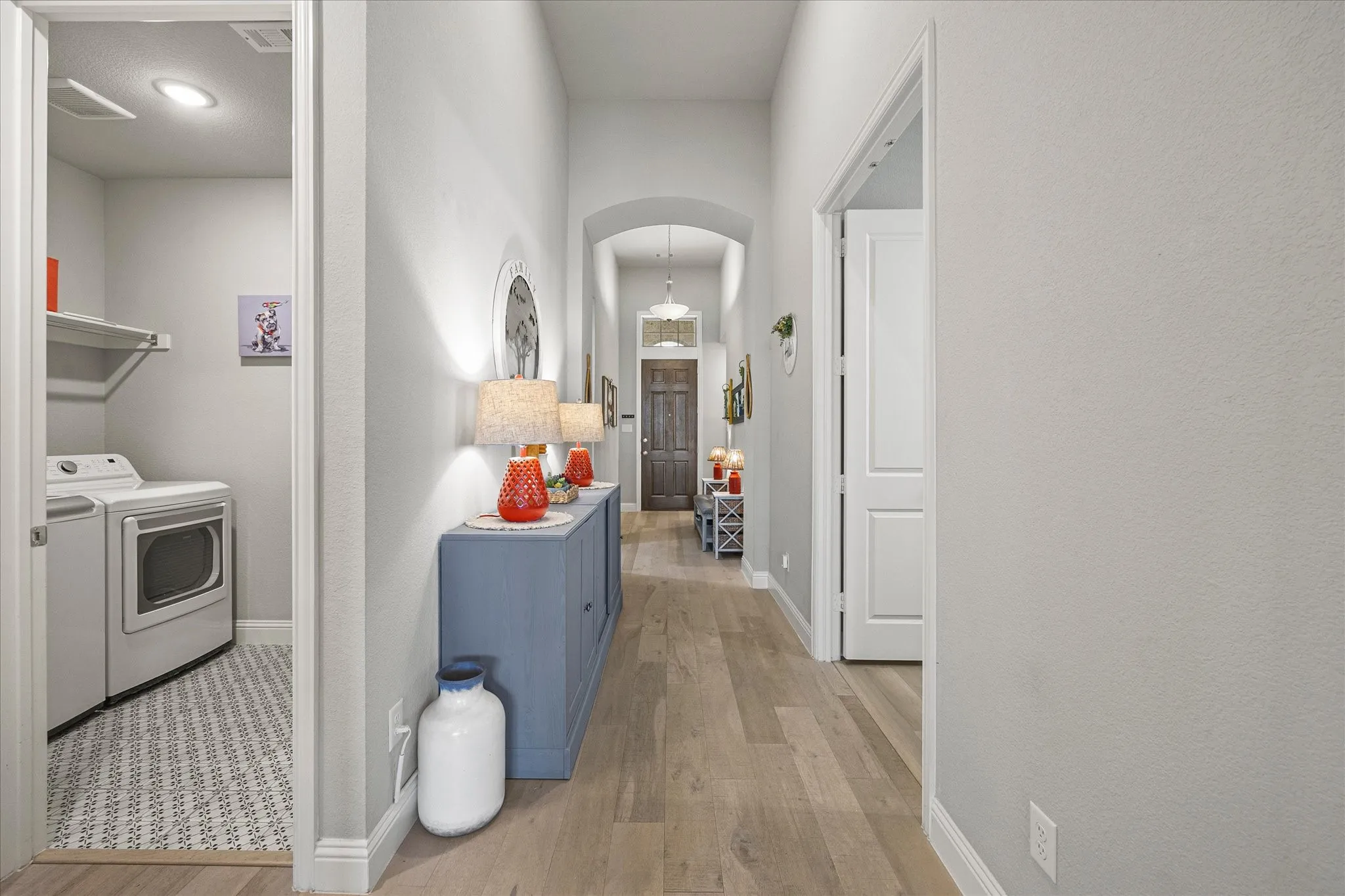 Hallway featuring wood-finish flooring, an arched entryway, and recessed lighting