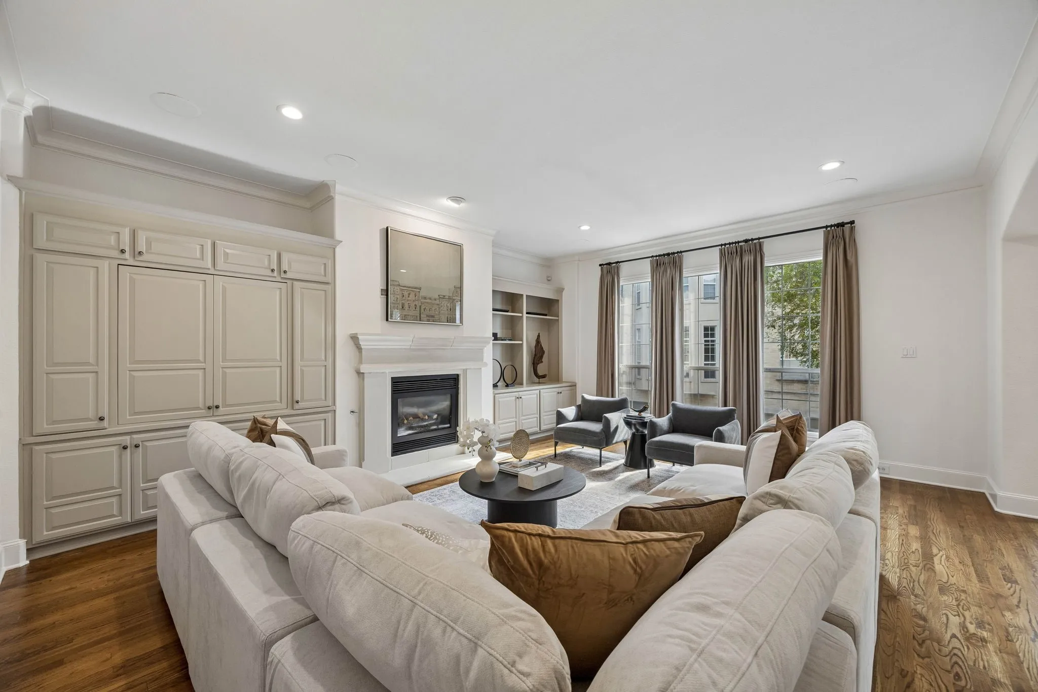 Inviting living room with a limestone facade gas fireplace and custom built-ins offering stylish storage and display space.