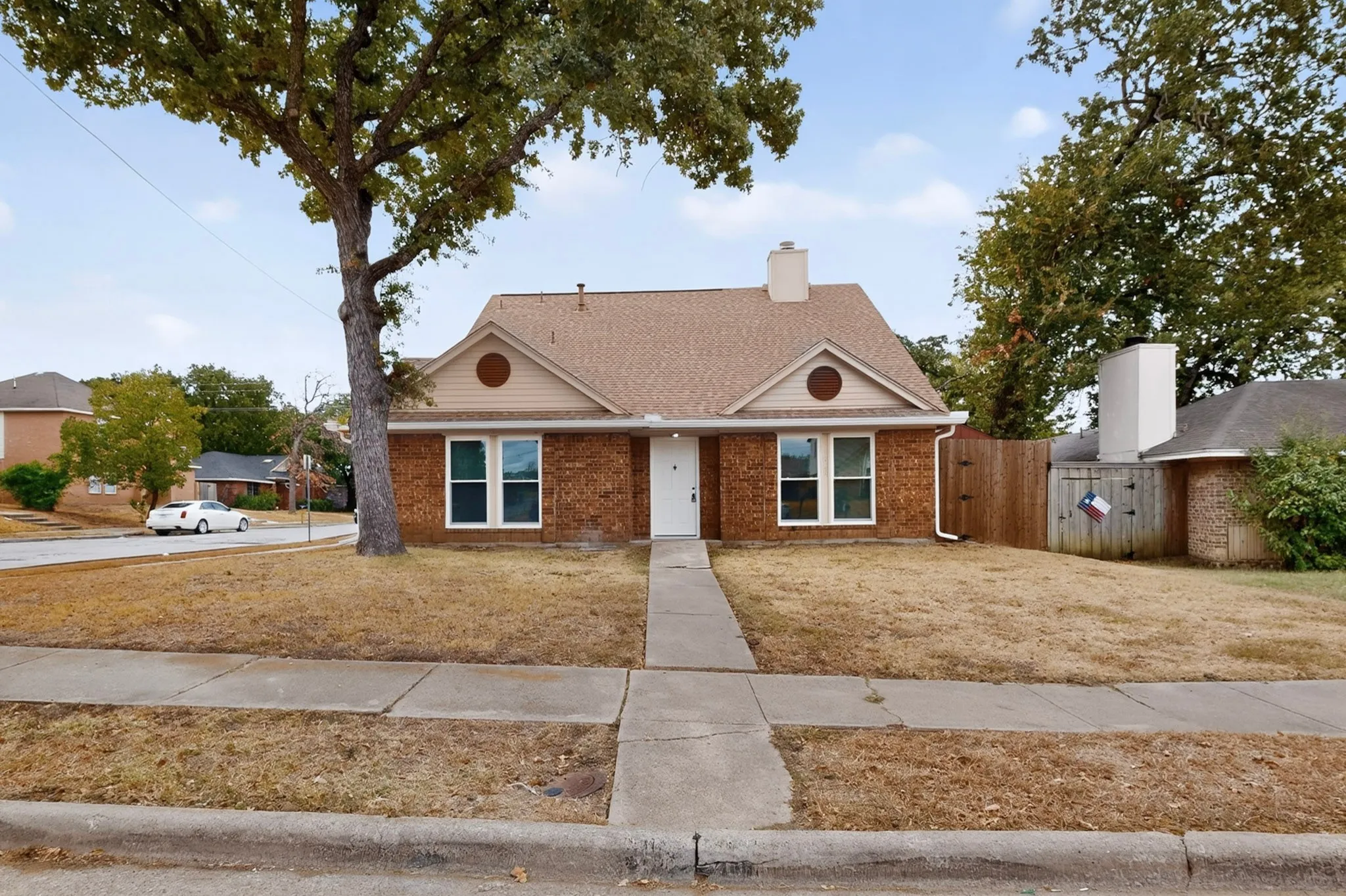 Brick facade with a gabled roof and front yard