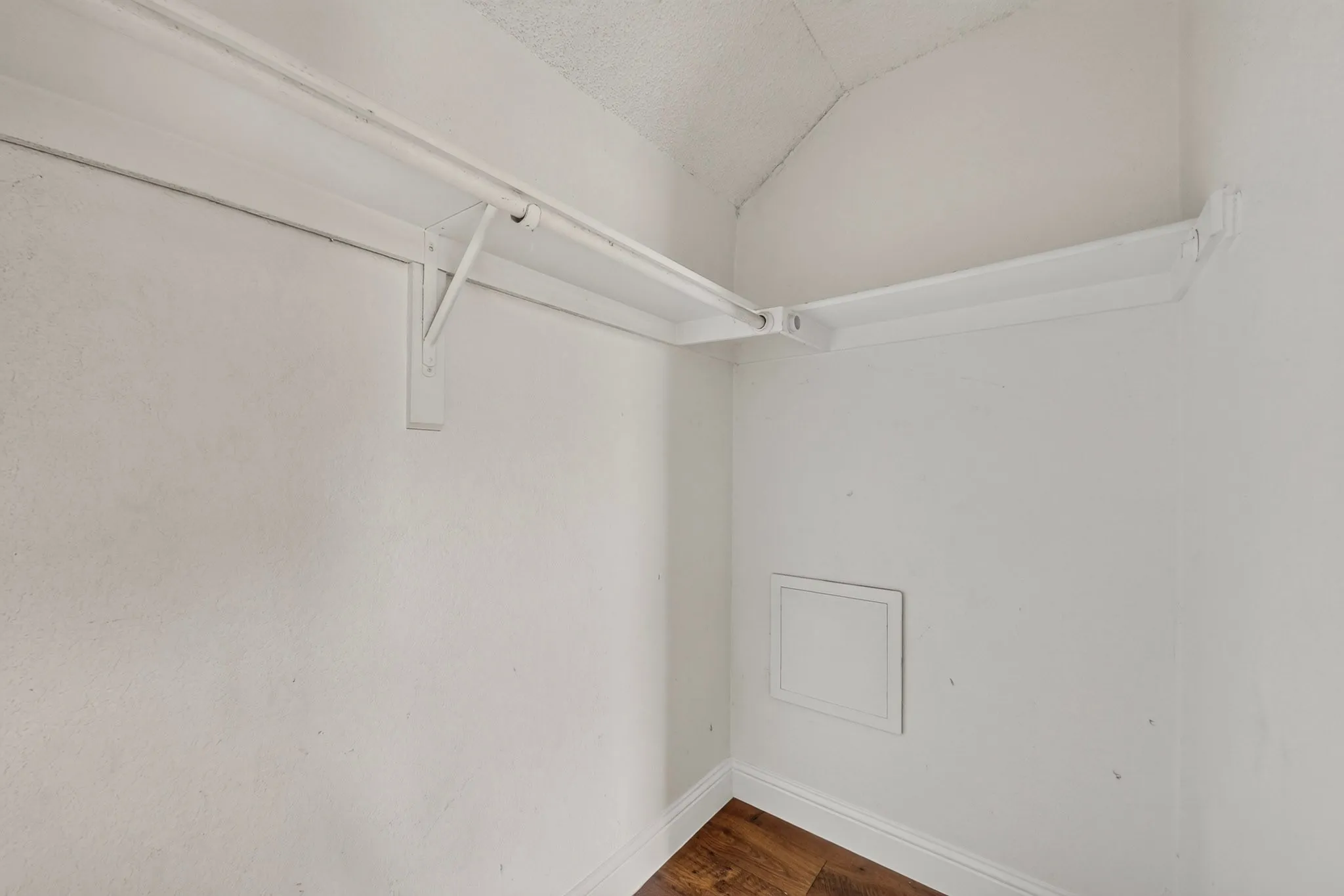 Closet featuring a built-in shelf, hanging rod, and wood-finish flooring