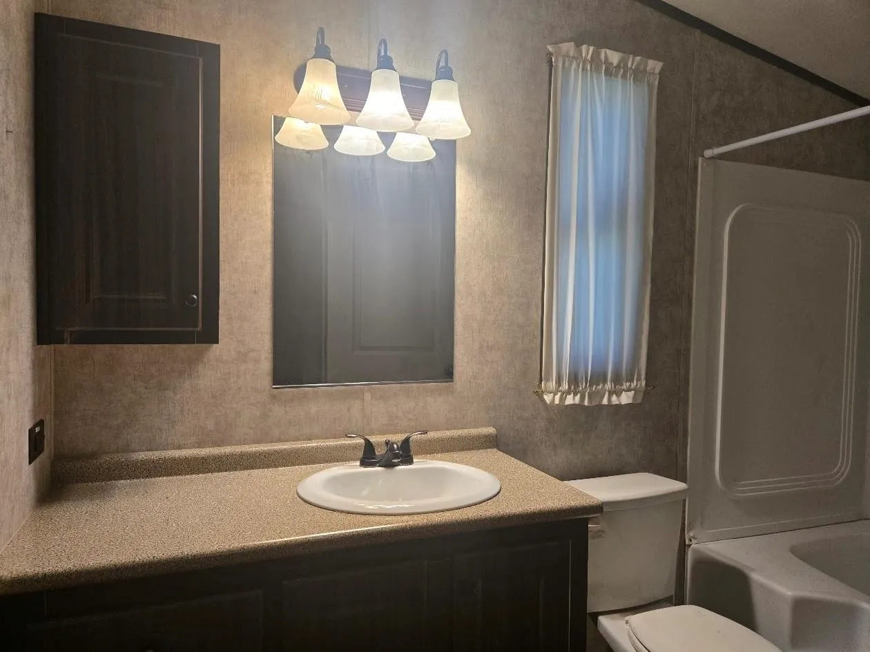 Vanity with an integrated sink and dark wood-finish cabinetry