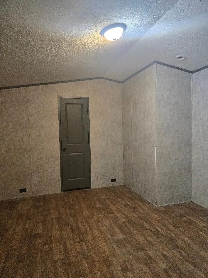 Wood-finish flooring with panel walls and a flush-mount ceiling light