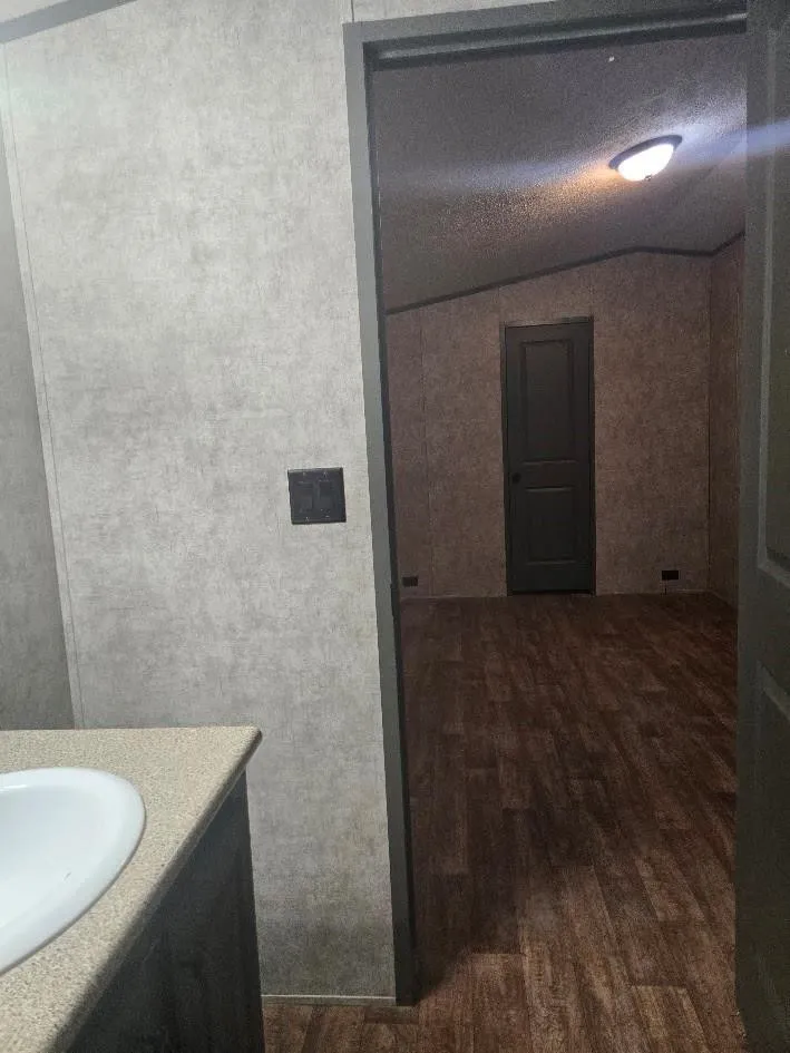 White oval undermount sink, laminate countertop, wood-finish flooring, and recessed lighting
