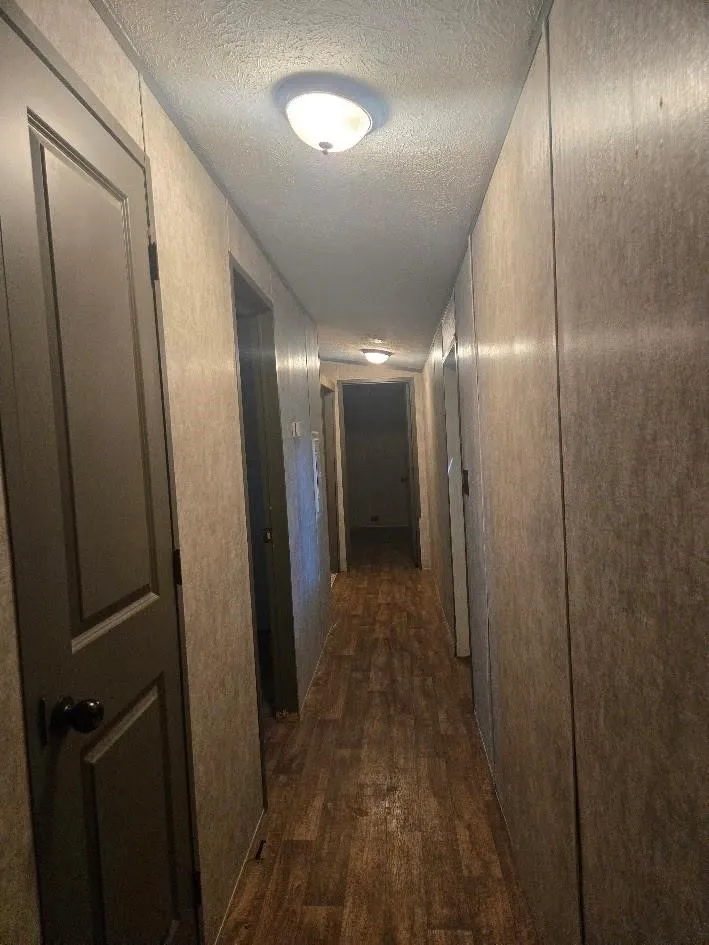 Wood-finish flooring throughout the hallway, complemented by neutral-toned wall panels